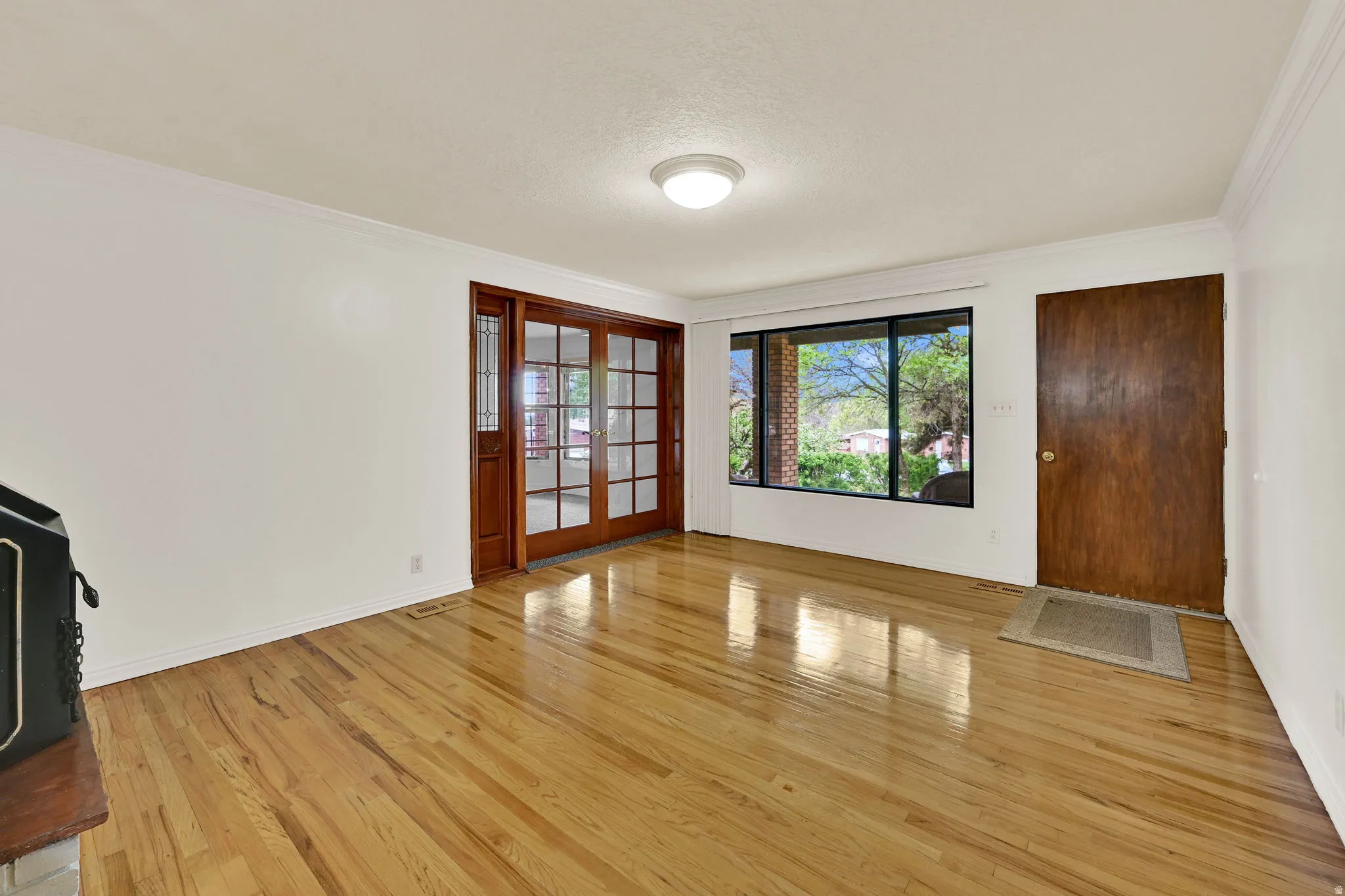 Foyer featuring light wood-style flooring, ornamental molding, and a textured ceiling