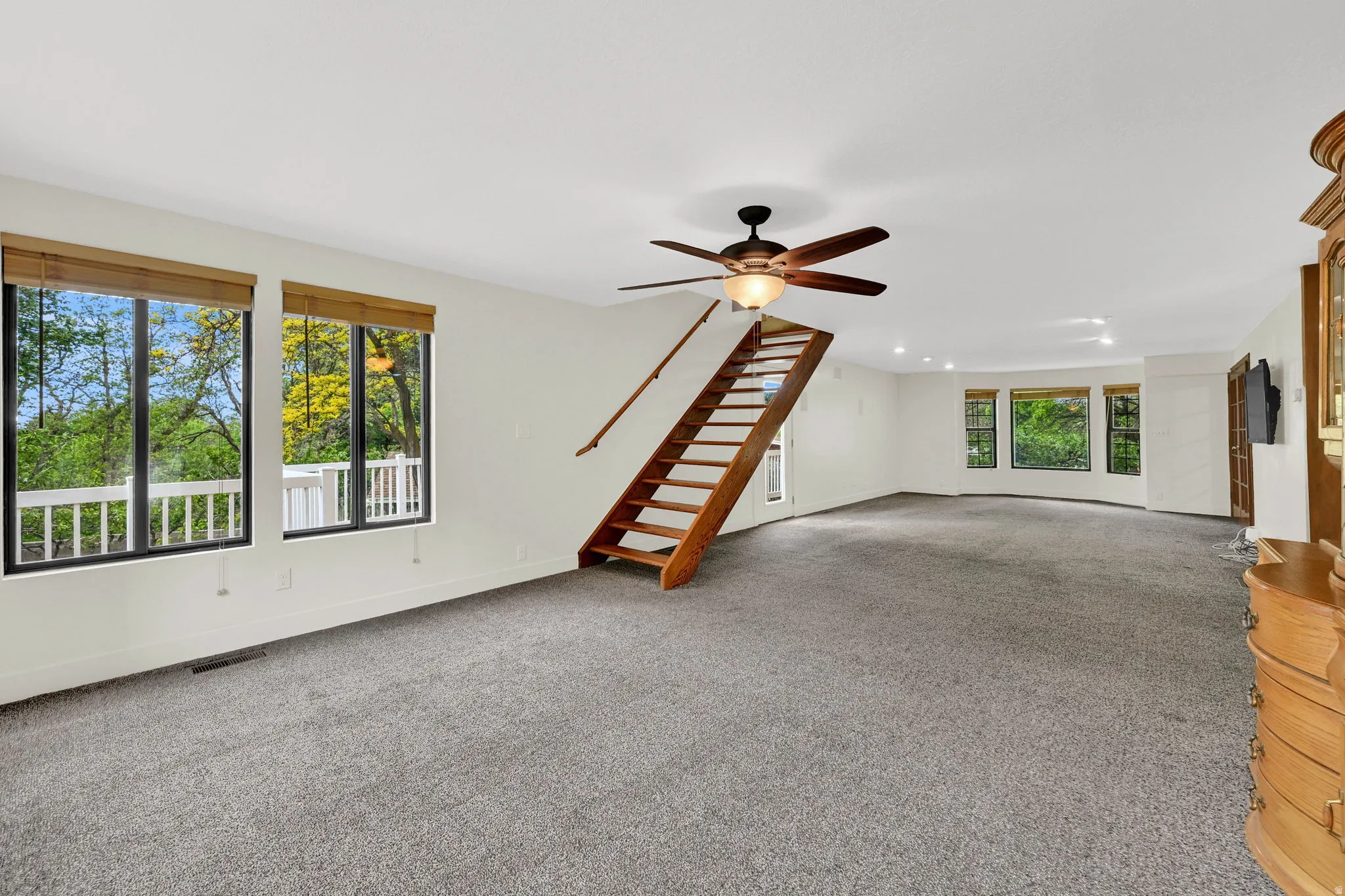 Unfurnished living room with a ceiling fan and carpet