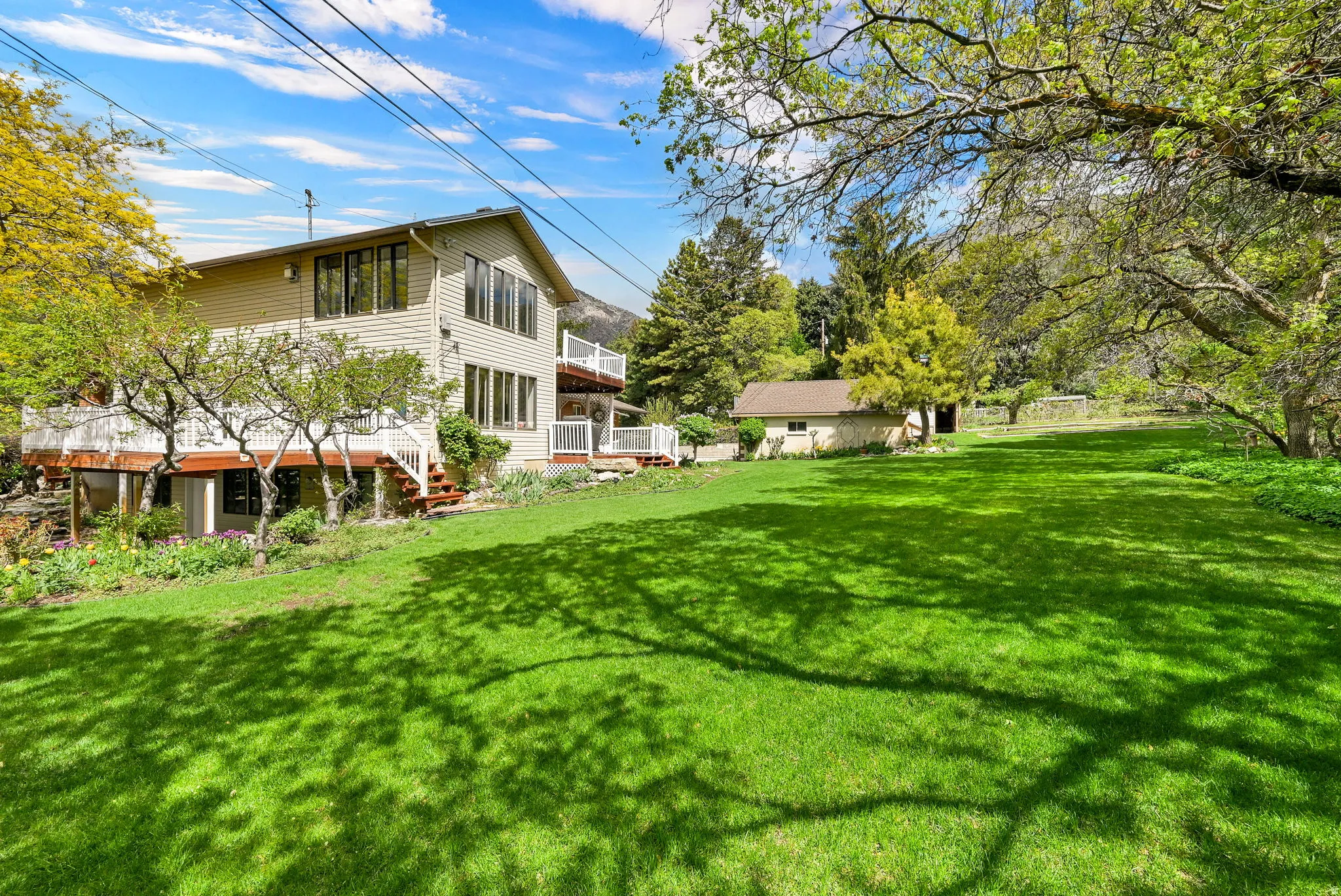 View of green lawn with a wooden deck and stairway