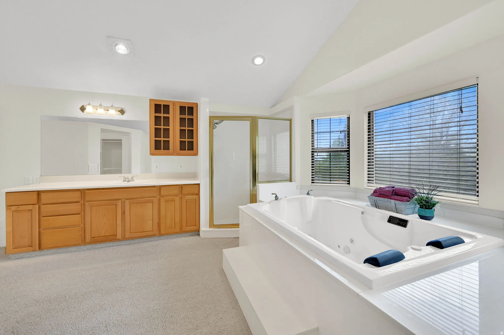 Full bath with vaulted ceiling, vanity, a shower stall, a jetted tub, and recessed lighting