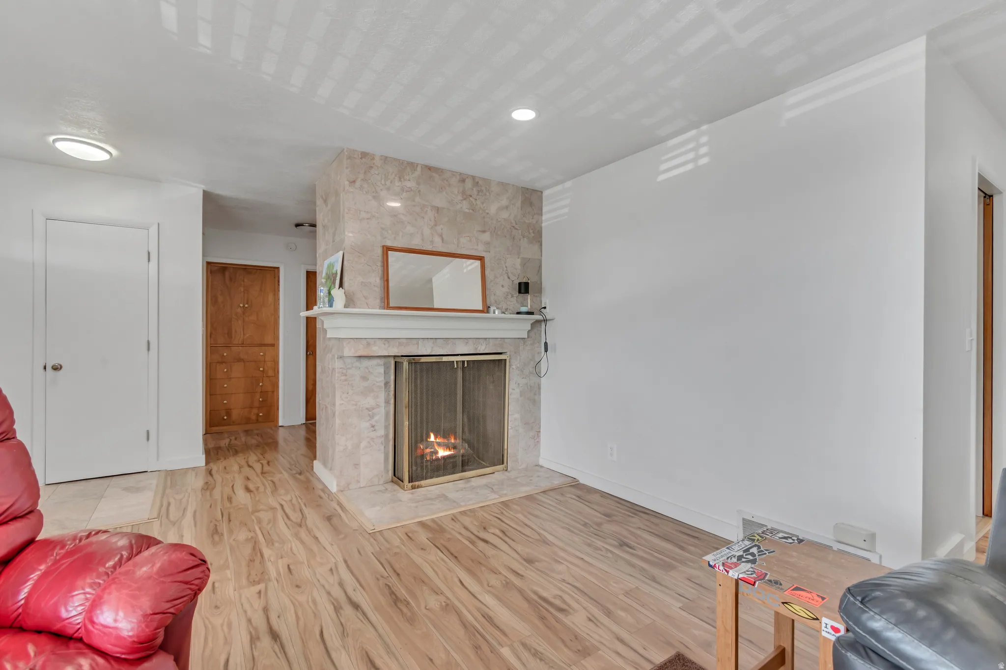Living room with a gas fireplace and light wood-type flooring