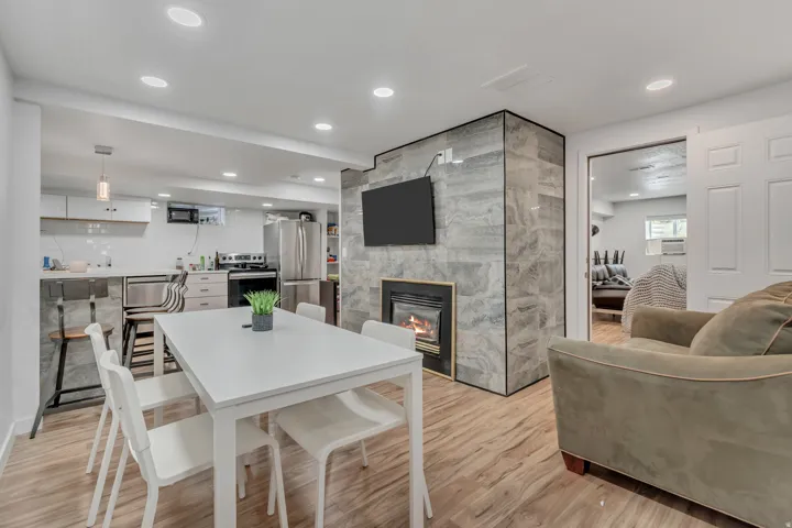 Dining area featuring light wood-style floors, a large fireplace, and recessed lighting