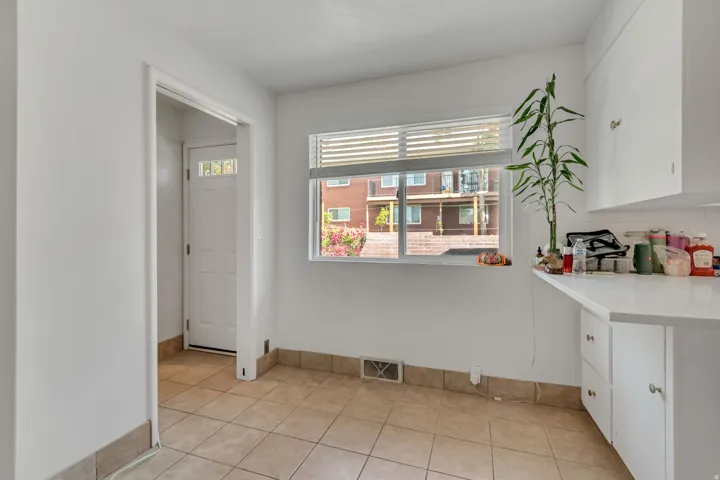 Unfurnished dining area featuring light tile patterned floors and baseboards