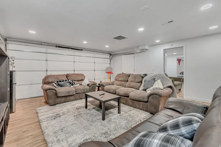 Living area featuring a garage, light wood-style floors, and recessed lighting