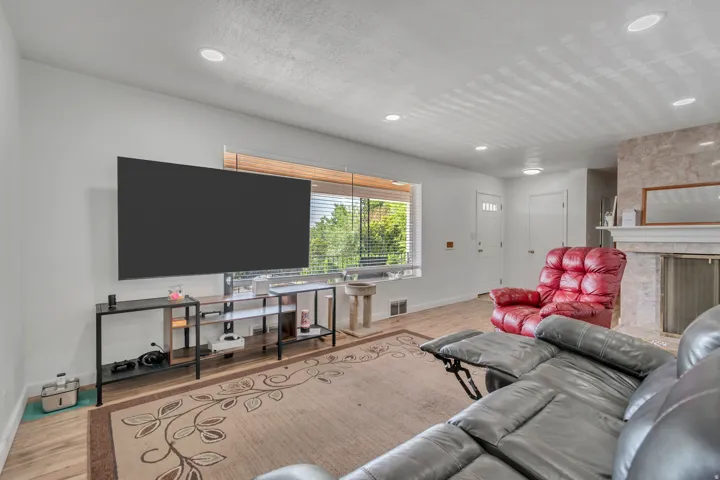 Living area featuring a high end fireplace, light wood-type flooring, and recessed lighting