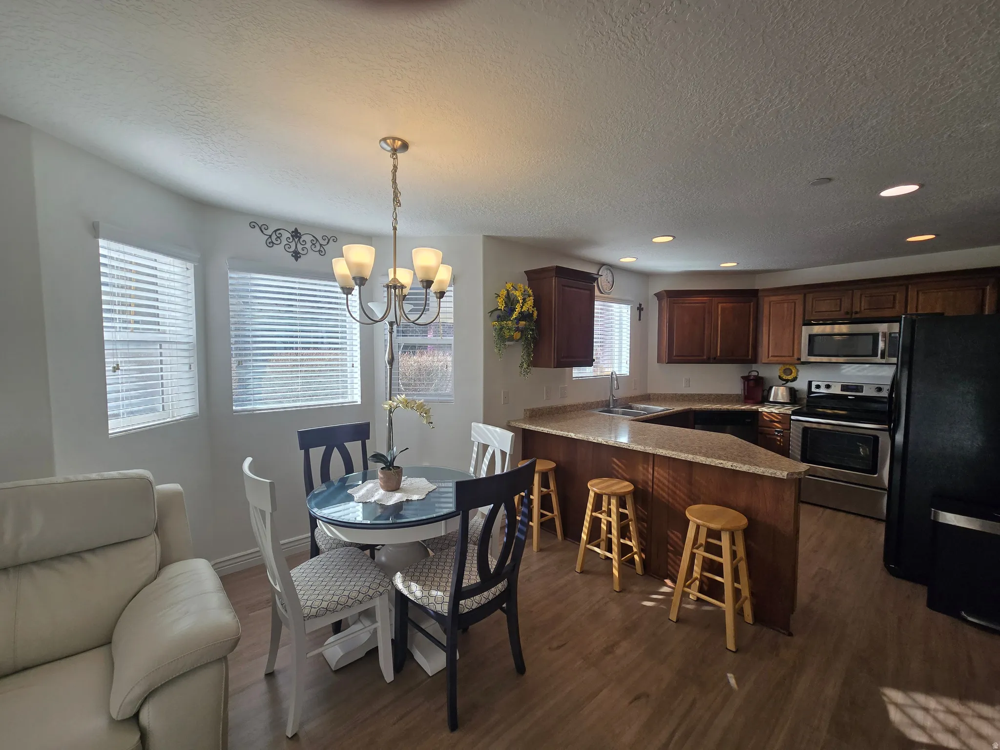 Dining space with suspended lighting, dark wood finished floors, and a textured ceiling