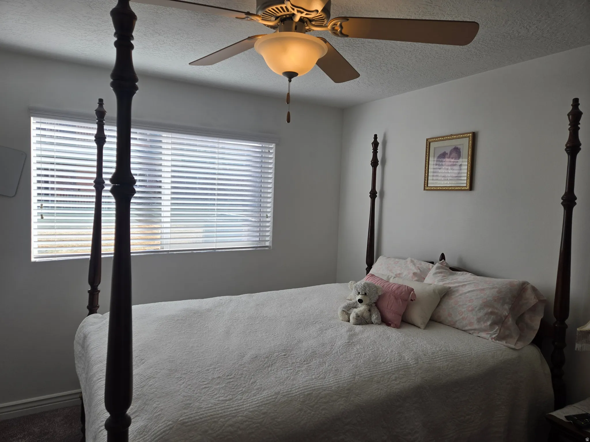 Bedroom with a textured ceiling and ceiling fan