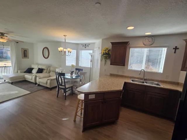 Kitchen with a peninsula, hanging lights, a ceiling fan, a breakfast bar, and healthy amount of natural light