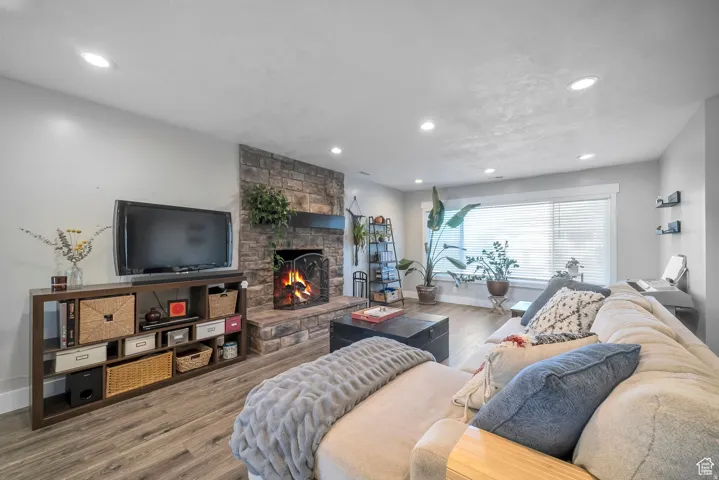 Living area with wood finished floors, a fireplace, and recessed lighting