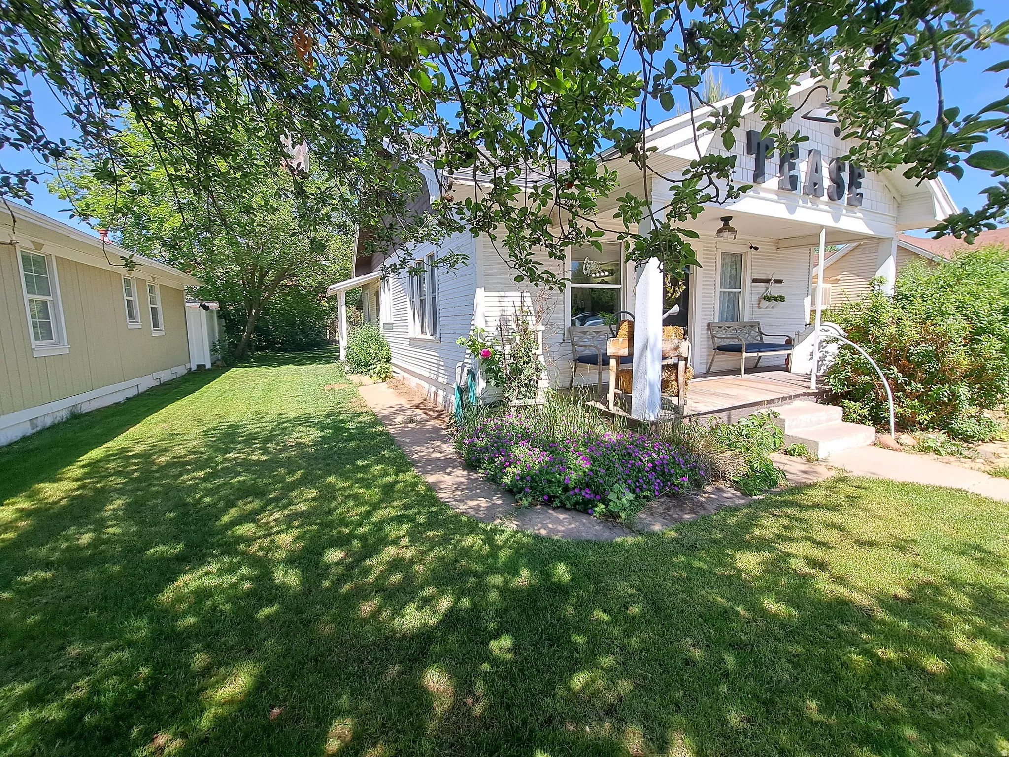 Back of house with a yard and covered porch
