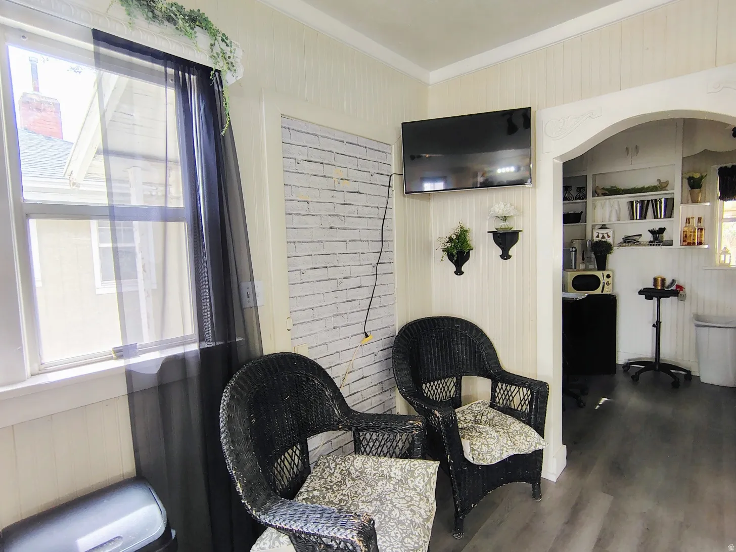 Area with radiator heating unit, wood finished floors, crown molding, wood walls, and built in shelves