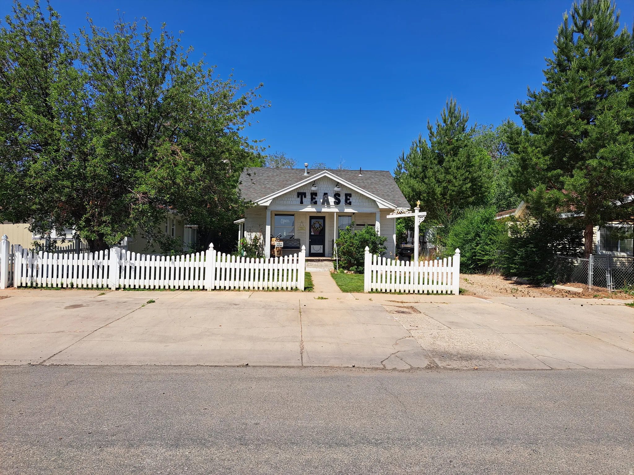 Bungalow-style house with a fenced front yard and covered porch, lots of parking