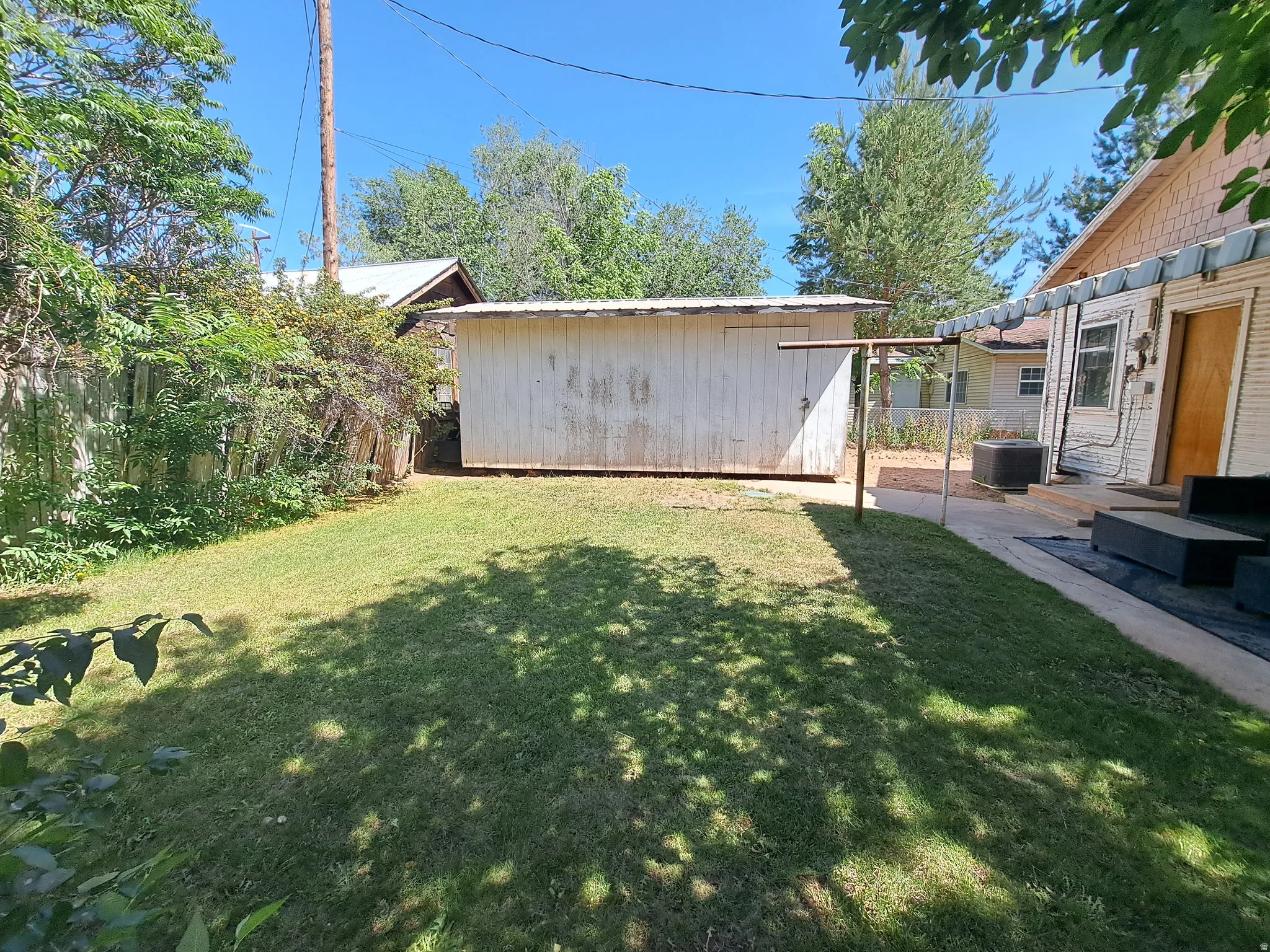 Fenced backyard with an outbuilding