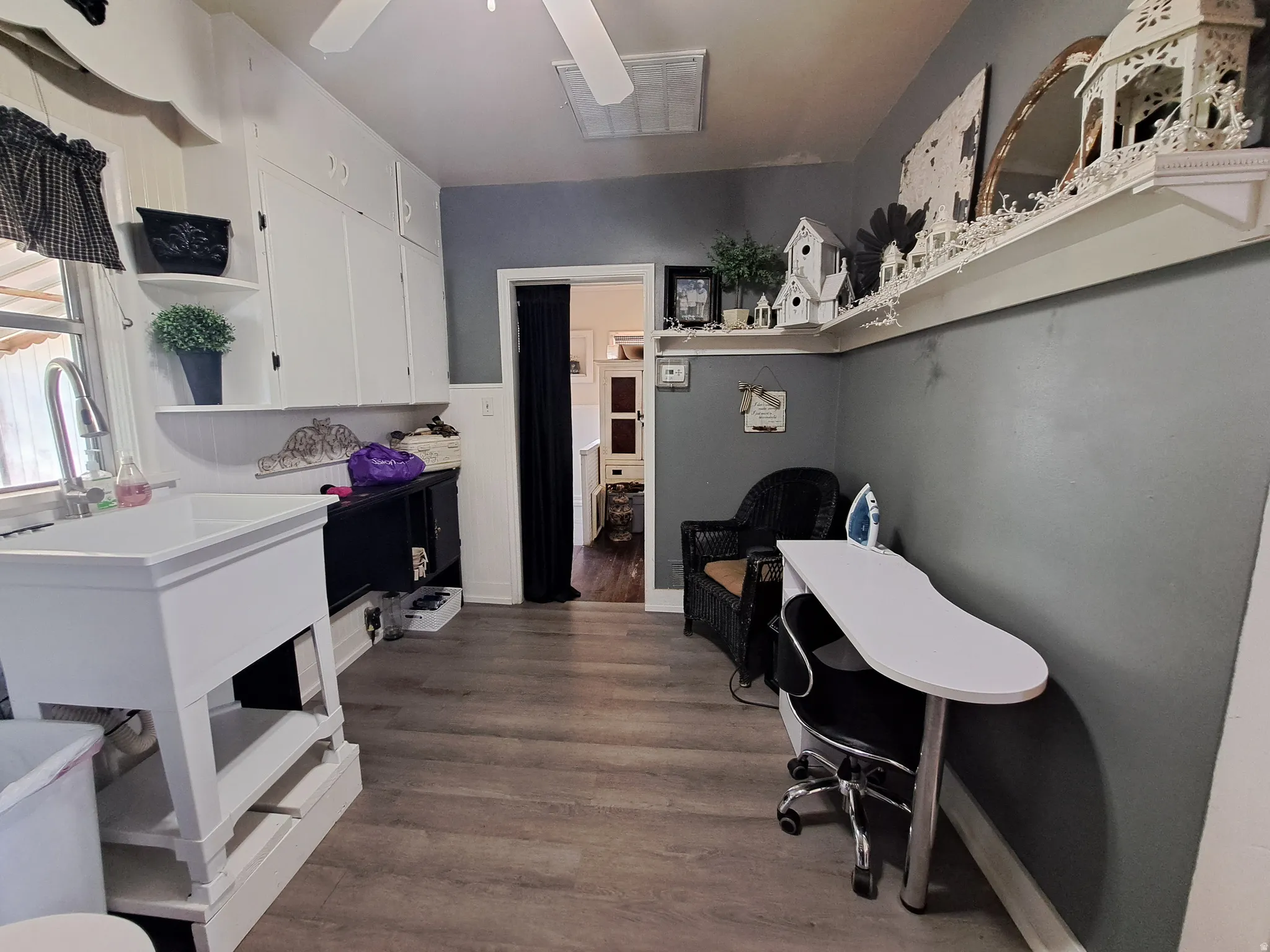 Office area with dark wood-style flooring and ceiling fan