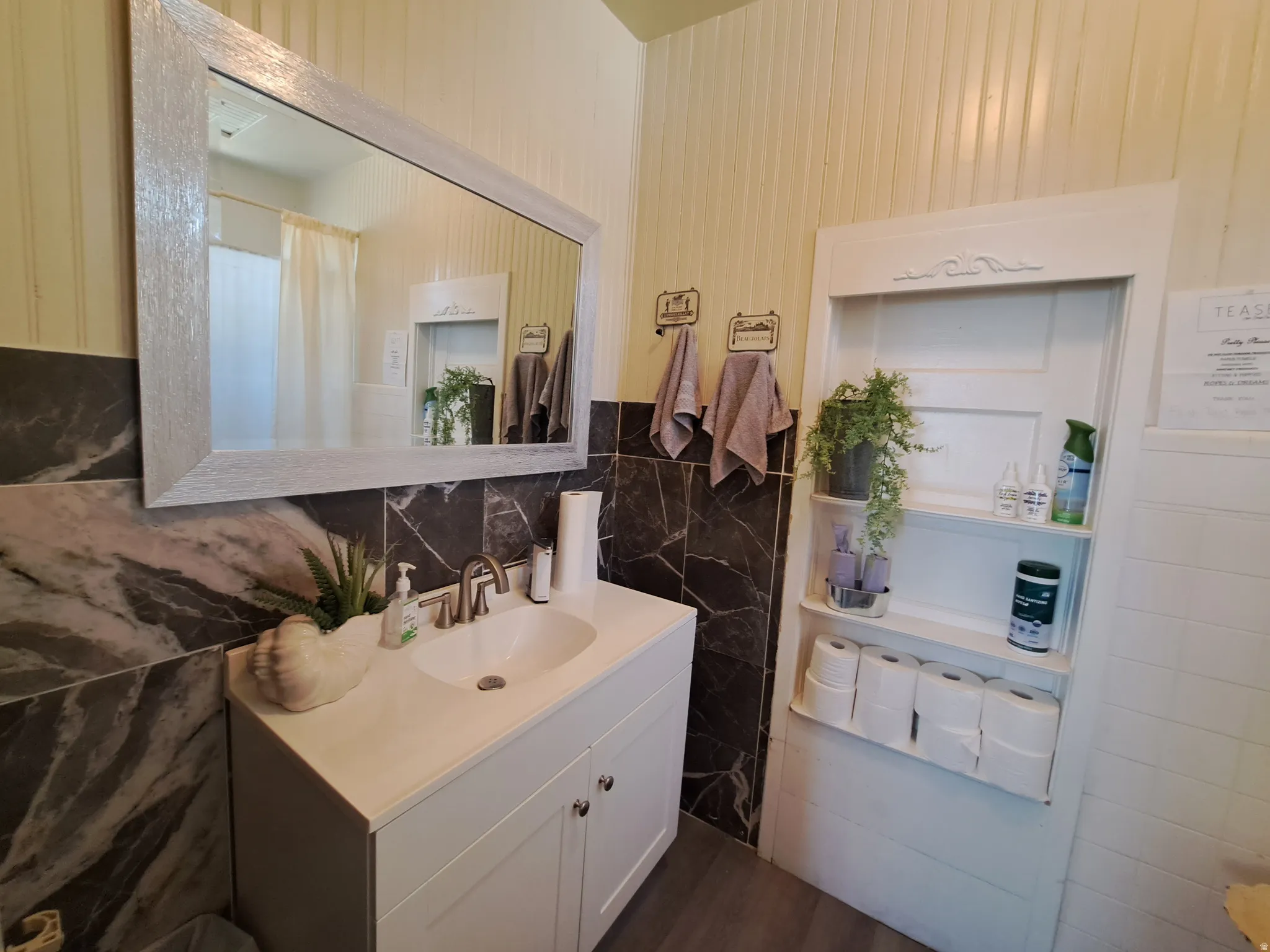 Bathroom with tile walls, vanity, and a shower with curtain