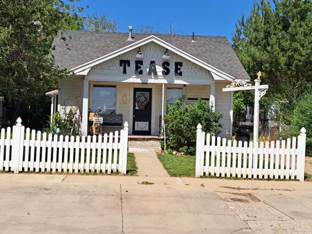 Bungalow-style home featuring roof with shingles and a fenced front yard