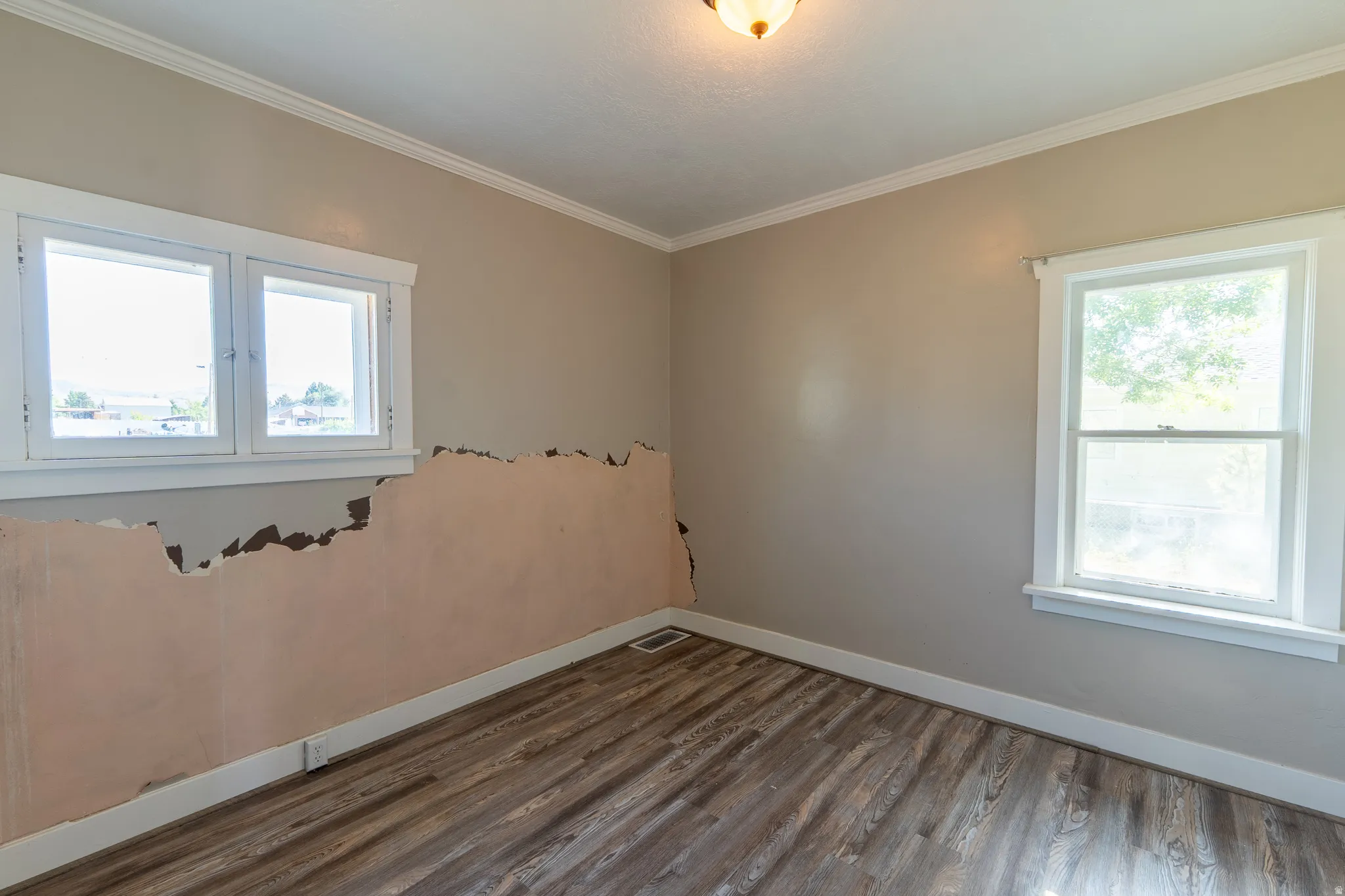 Unfurnished room with dark wood-style flooring and crown molding
