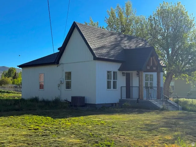 Rear view of house with a lawn and a porch