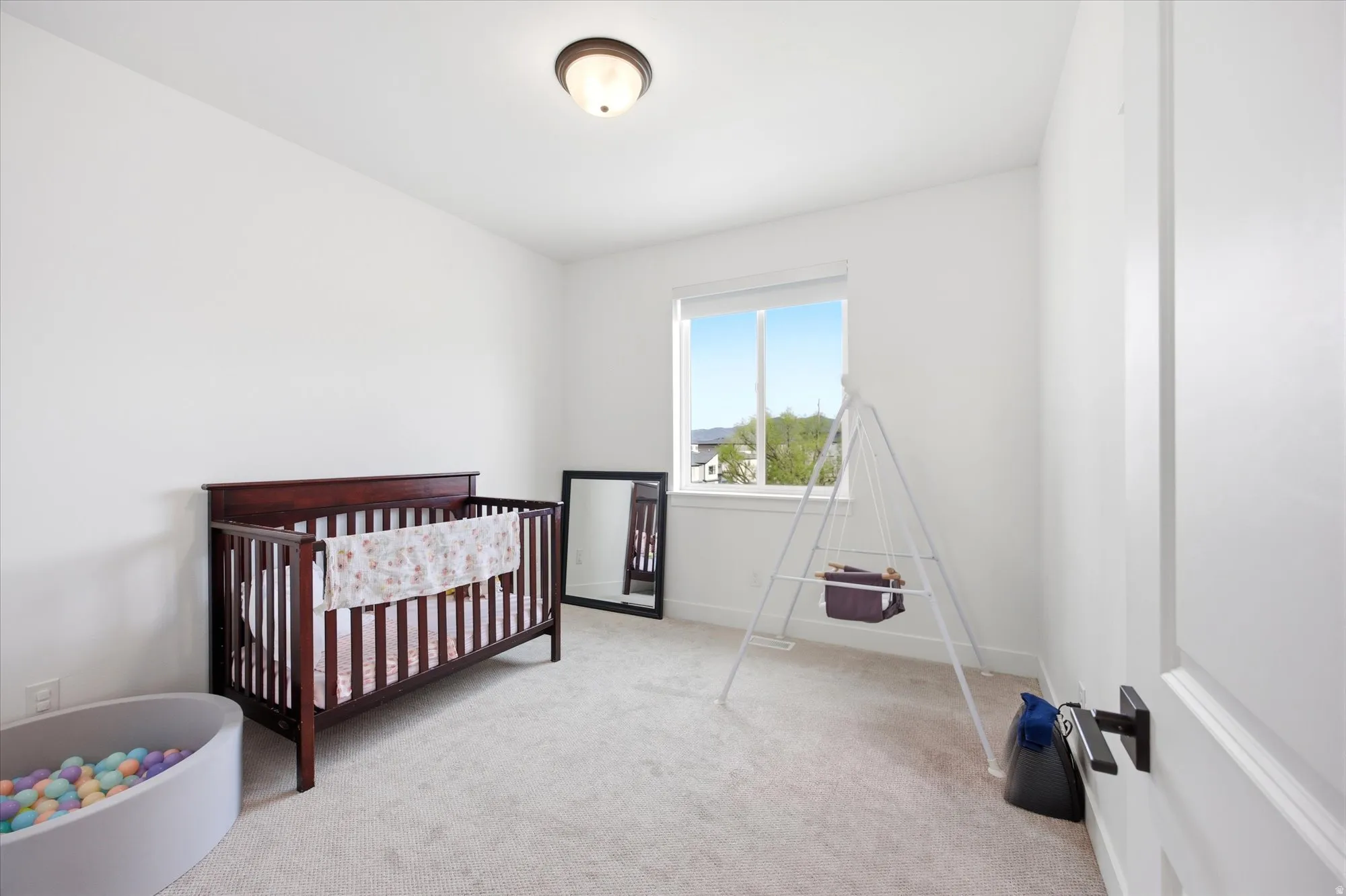 Bedroom with a crib and light carpet