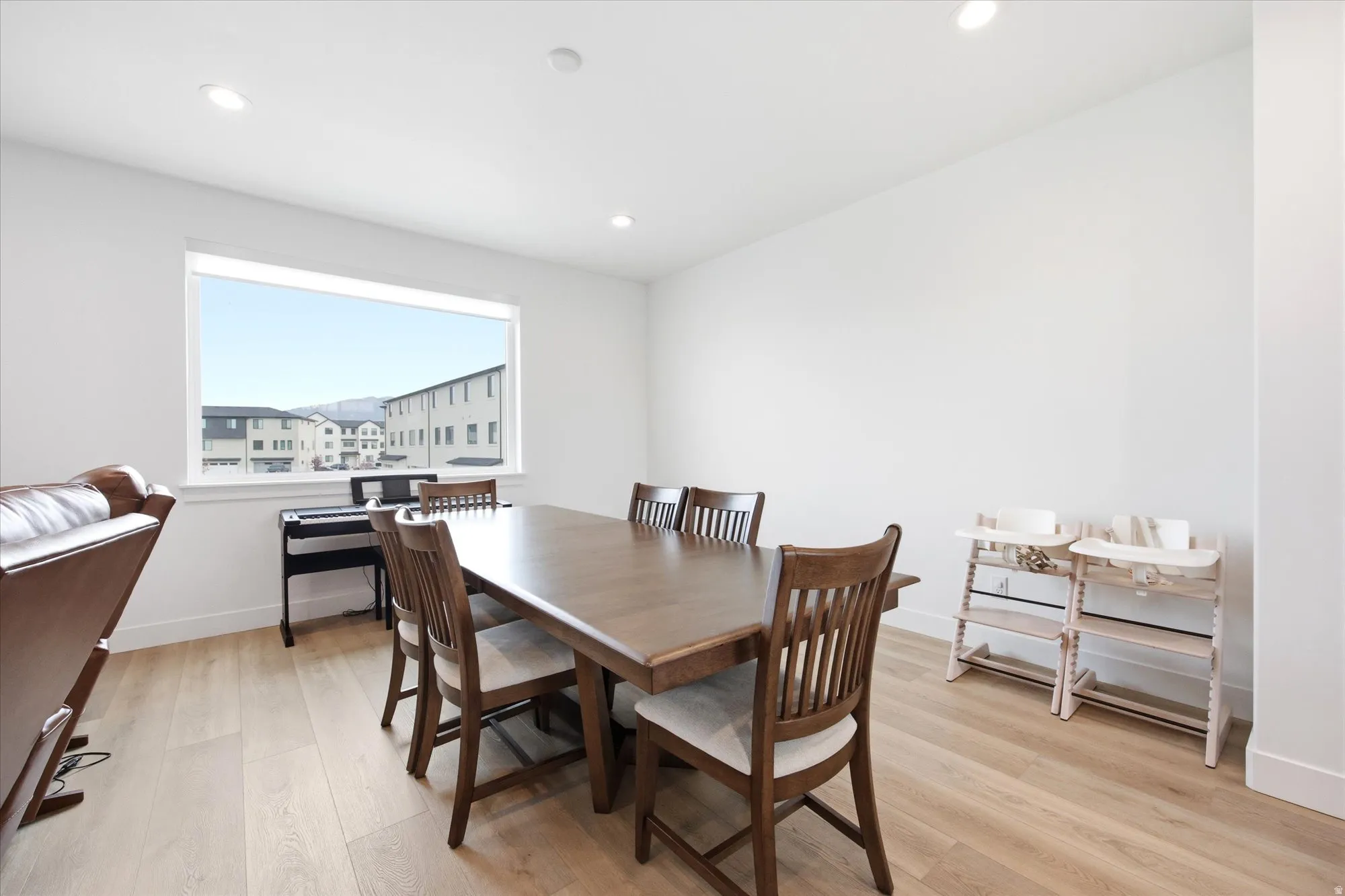 Dining space with light wood finished floors and recessed lighting