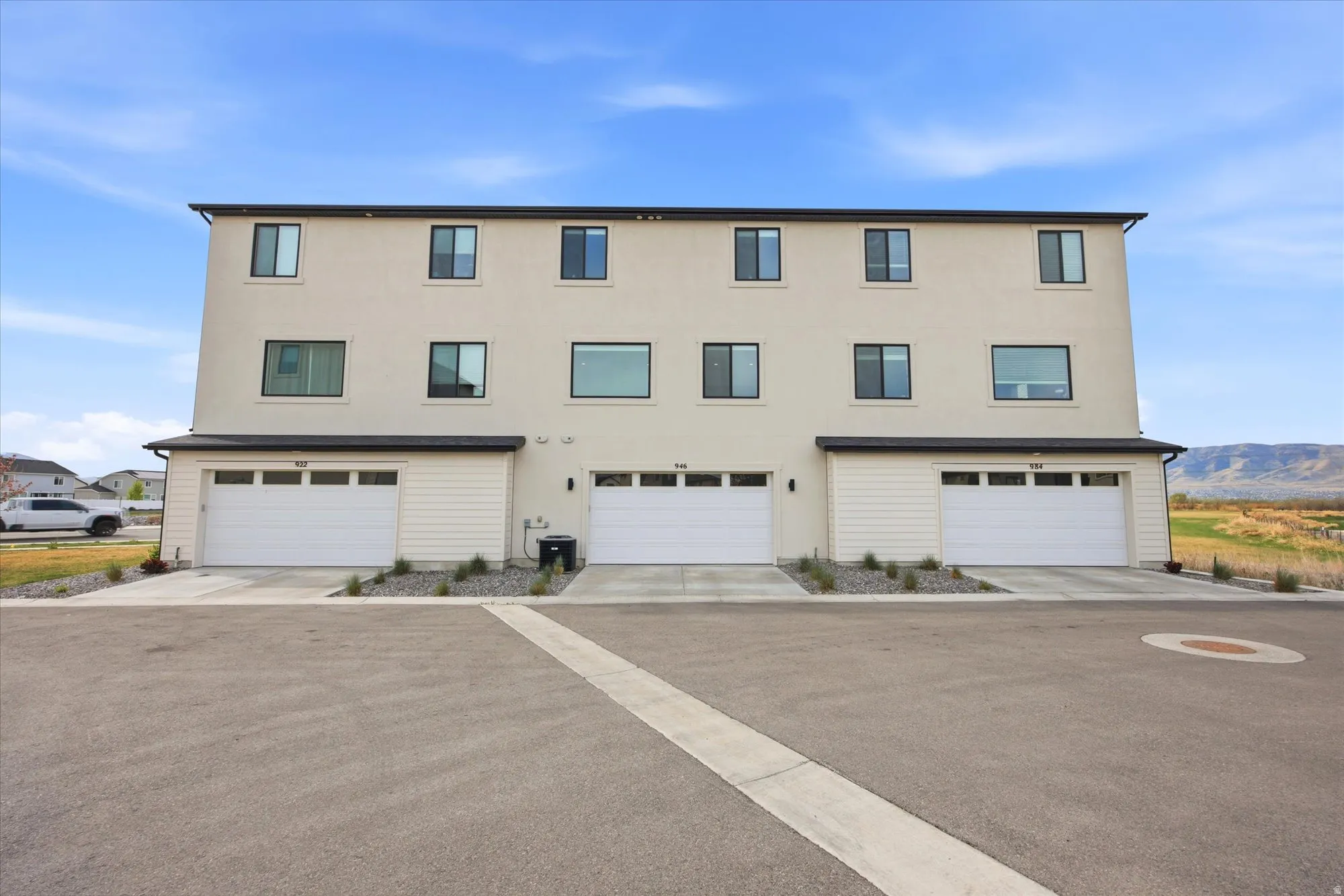 View of front facade with a garage, stucco siding, and driveway