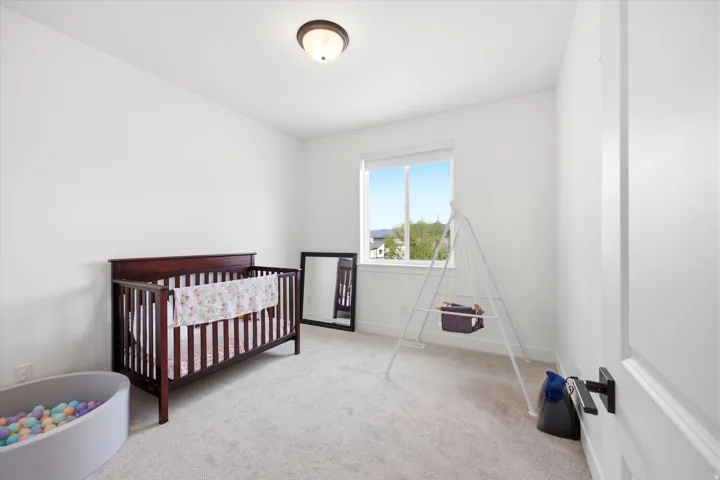 Bedroom with a crib and light carpet