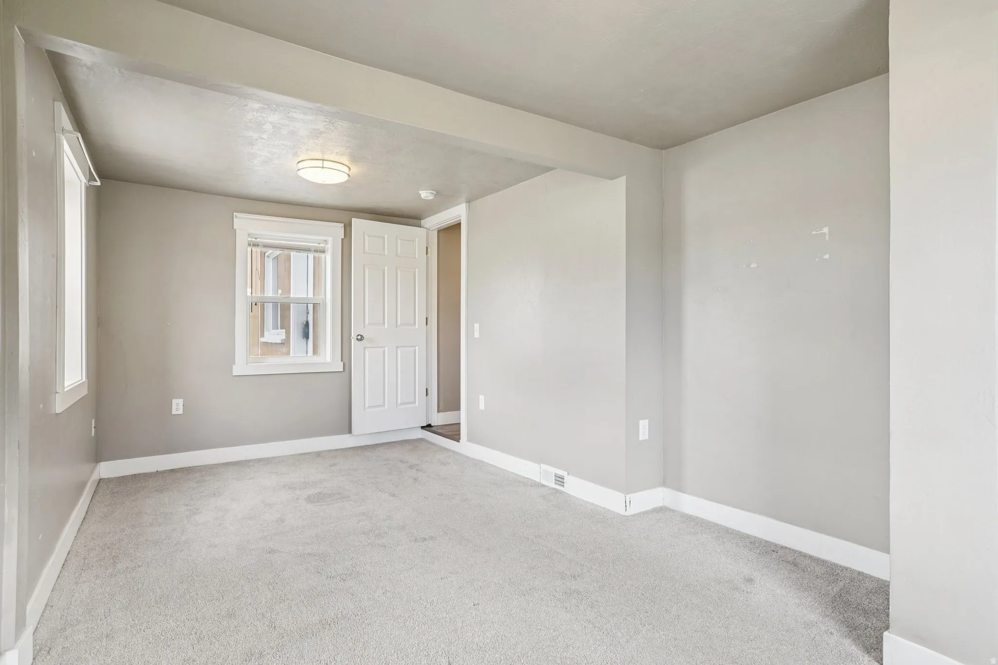Unfurnished room featuring baseboards and light colored carpet