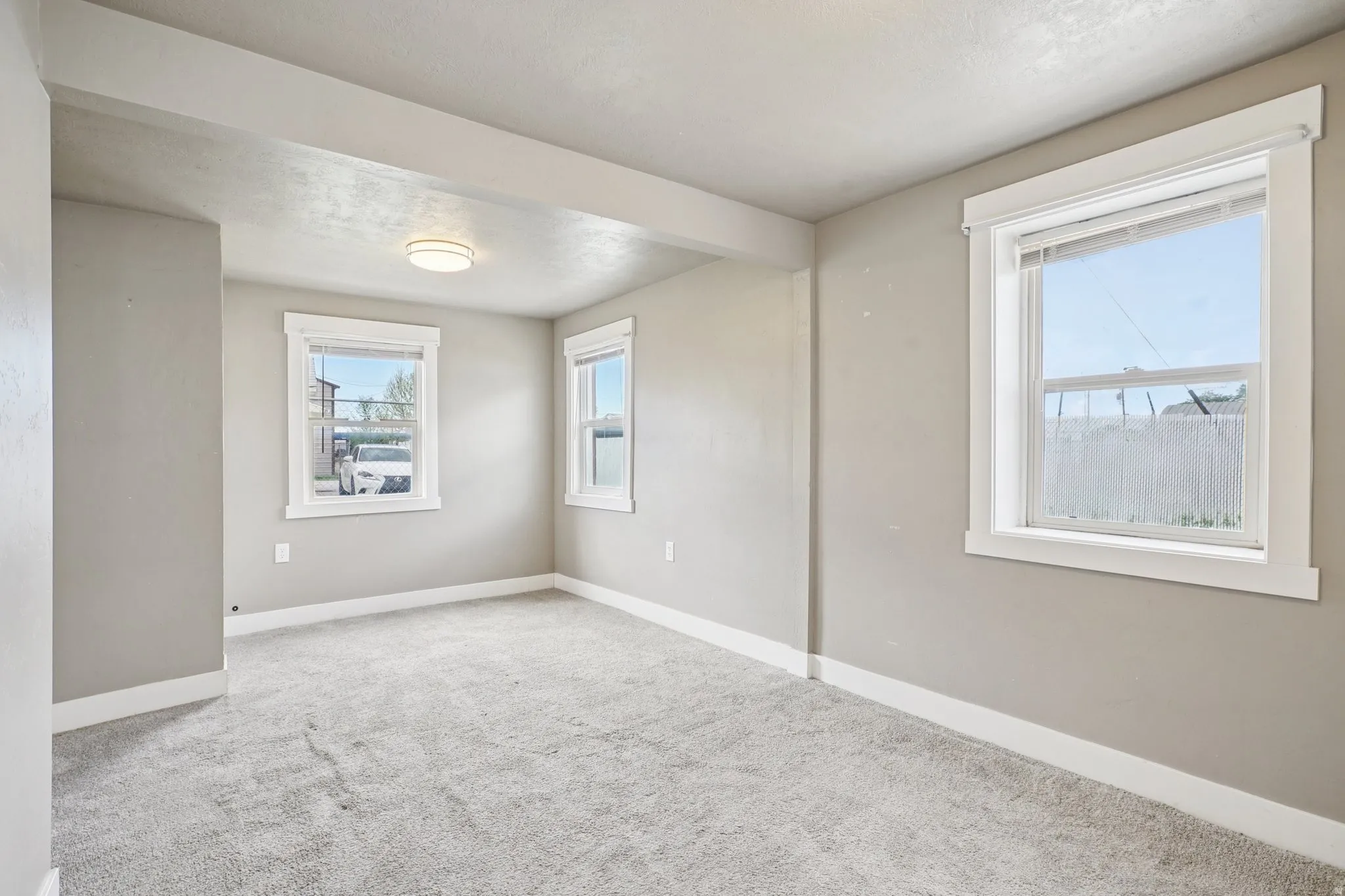 Carpeted spare room featuring baseboards