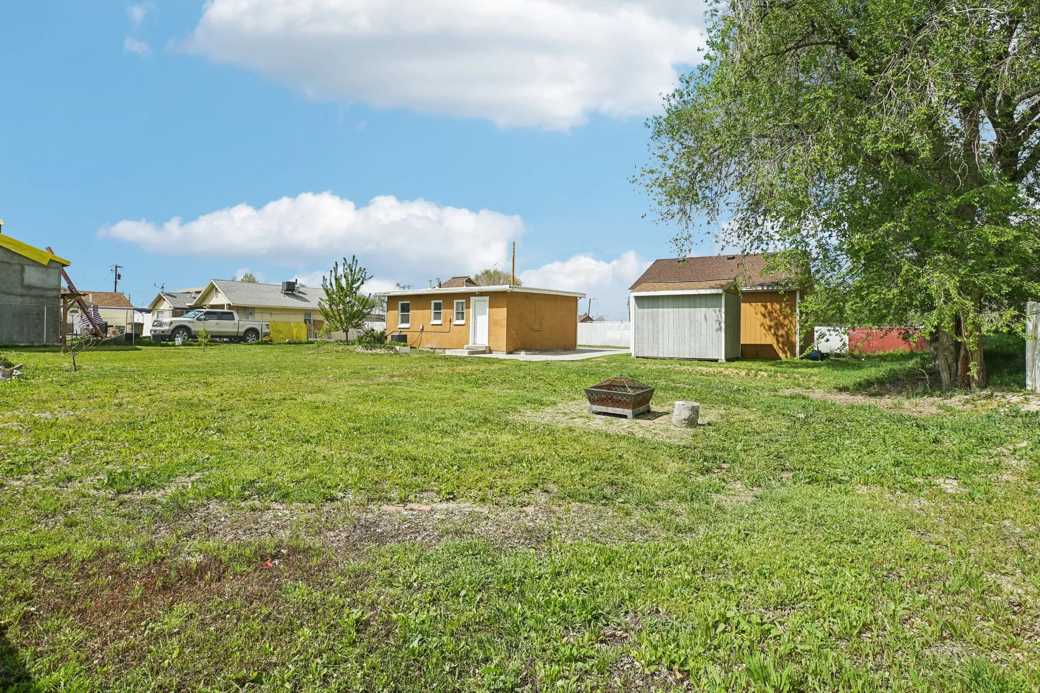 View of yard featuring a shed, a fire pit, and a patio area