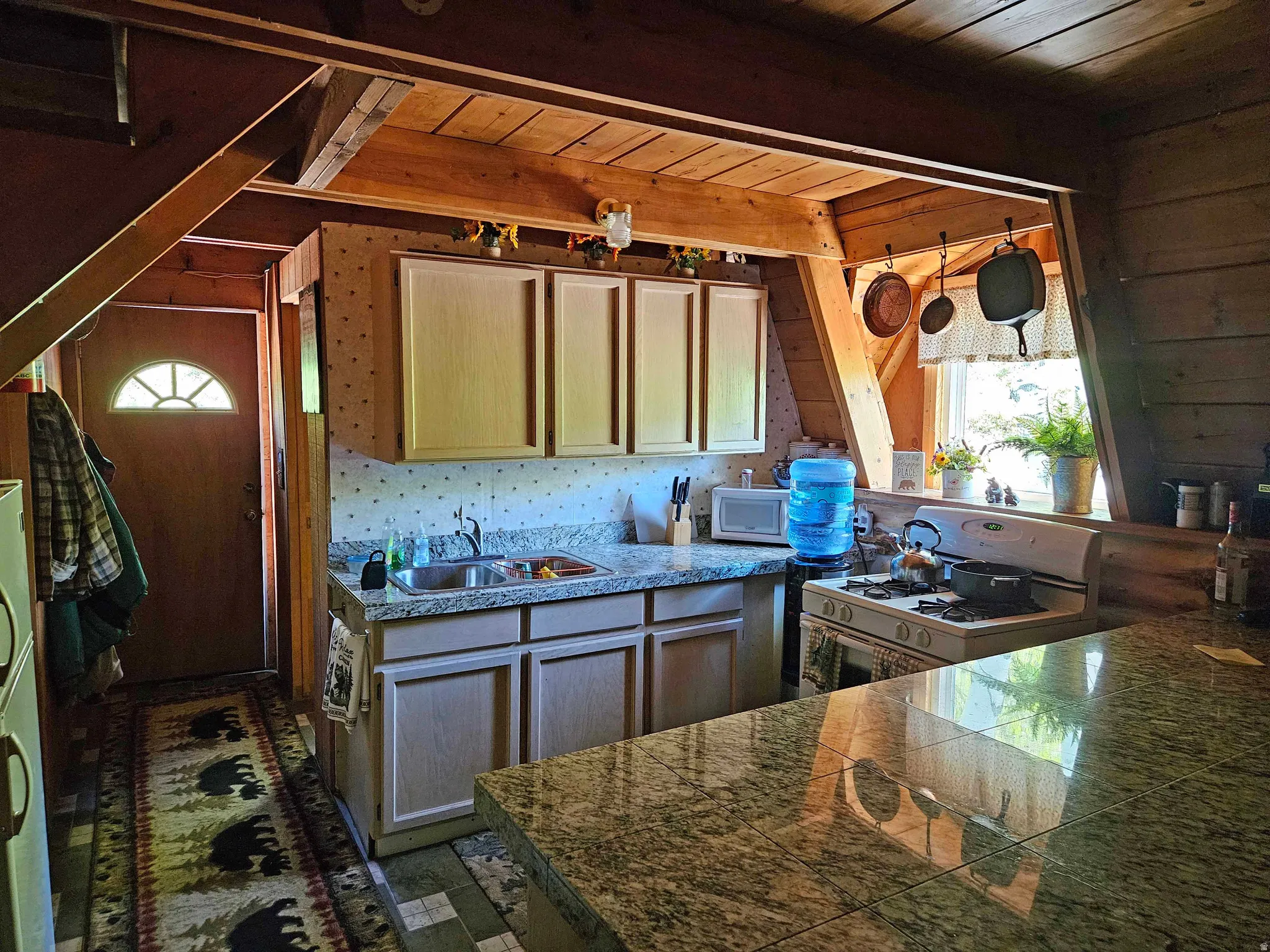 Kitchen featuring tile countertops, white appliances, healthy amount of natural light, and wood ceiling