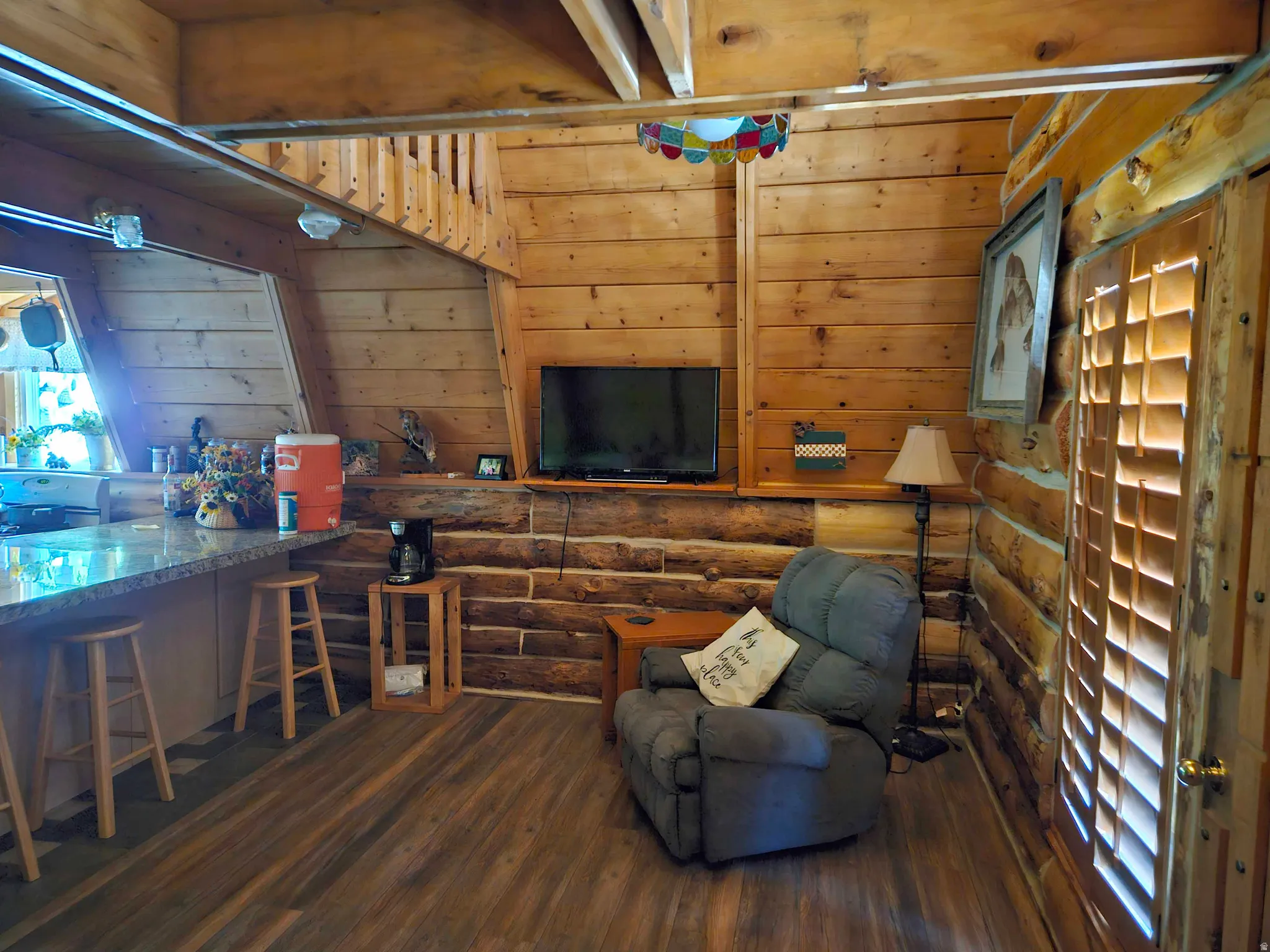 Living room with dark wood finished floors and wooden walls