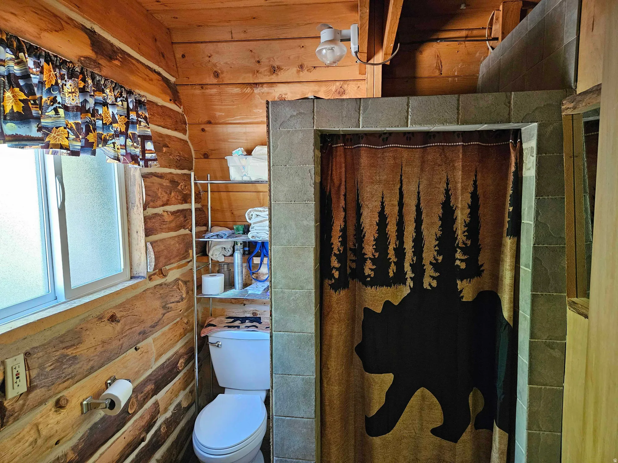 Full bath with curtained shower and wood walls