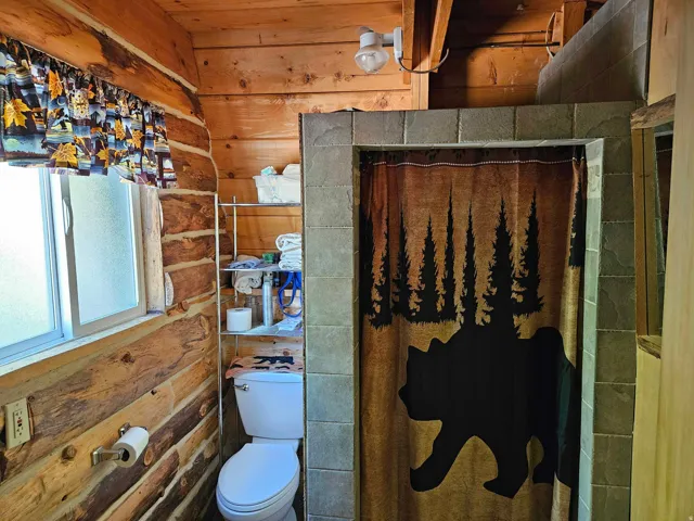 Full bath with curtained shower and wood walls