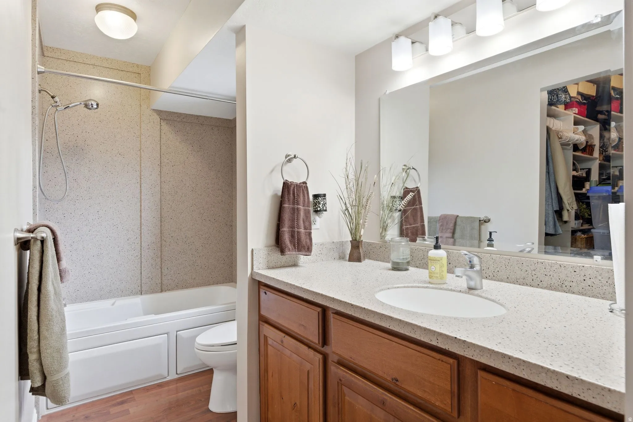 Full bathroom with vanity,  shower combination, and light wood-style flooring