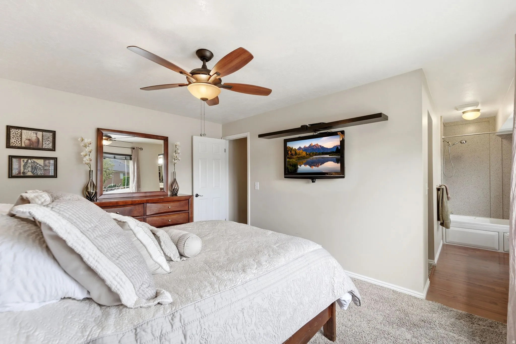 Bedroom with ceiling fan and light colored carpet