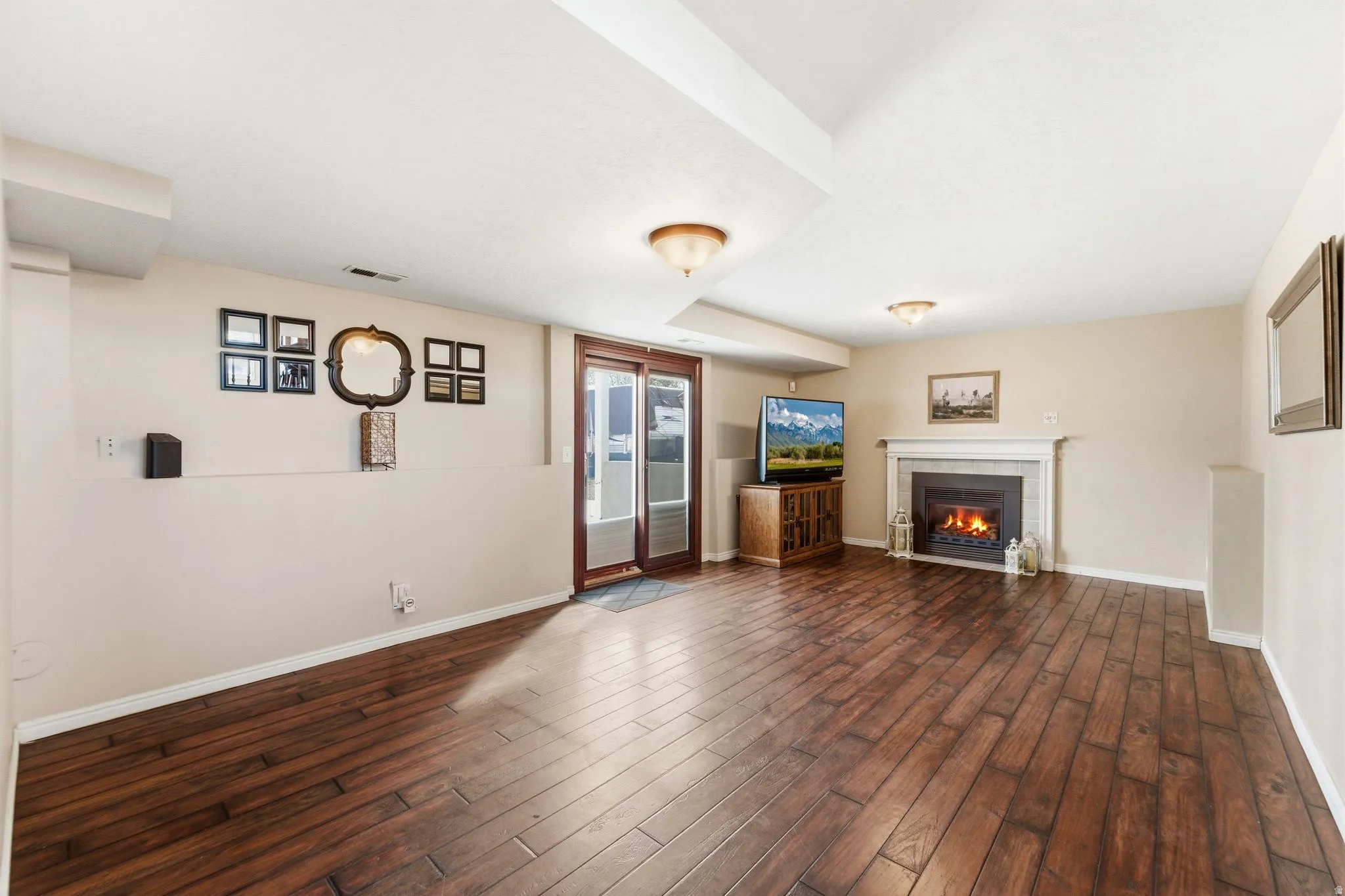 Unfurnished living room with dark wood-style floors and a fireplace