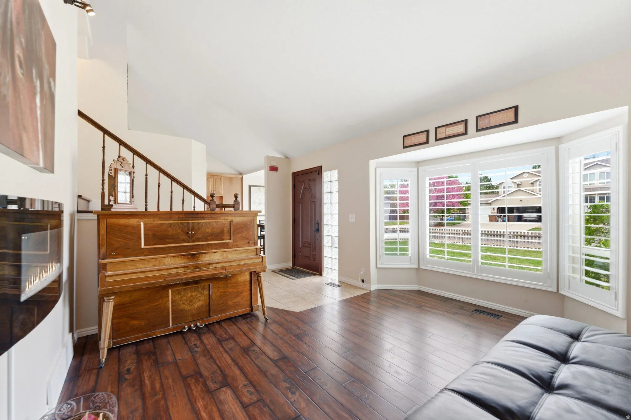 Living room with plenty of natural light, dark wood-style flooring, and lofted ceiling