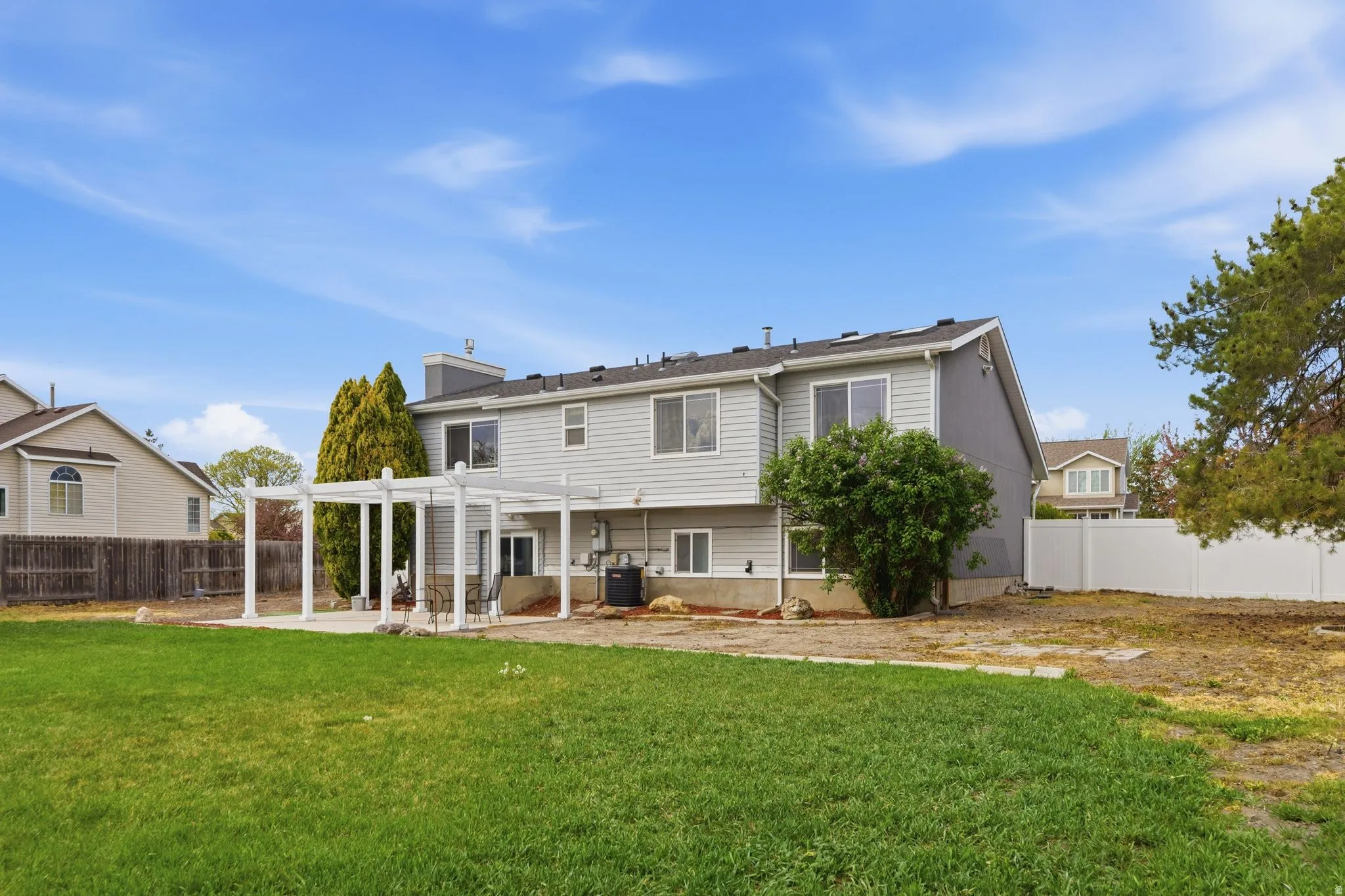 Rear view of property with a pergola, a fenced backyard, a patio, and a chimney