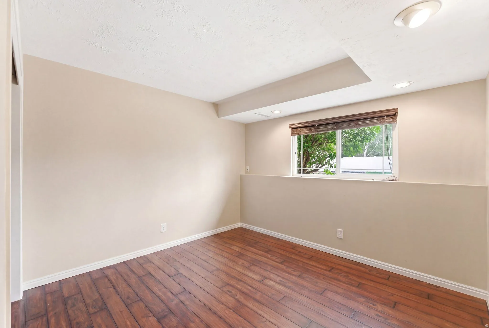 Unfurnished room with dark wood-style flooring and recessed lighting