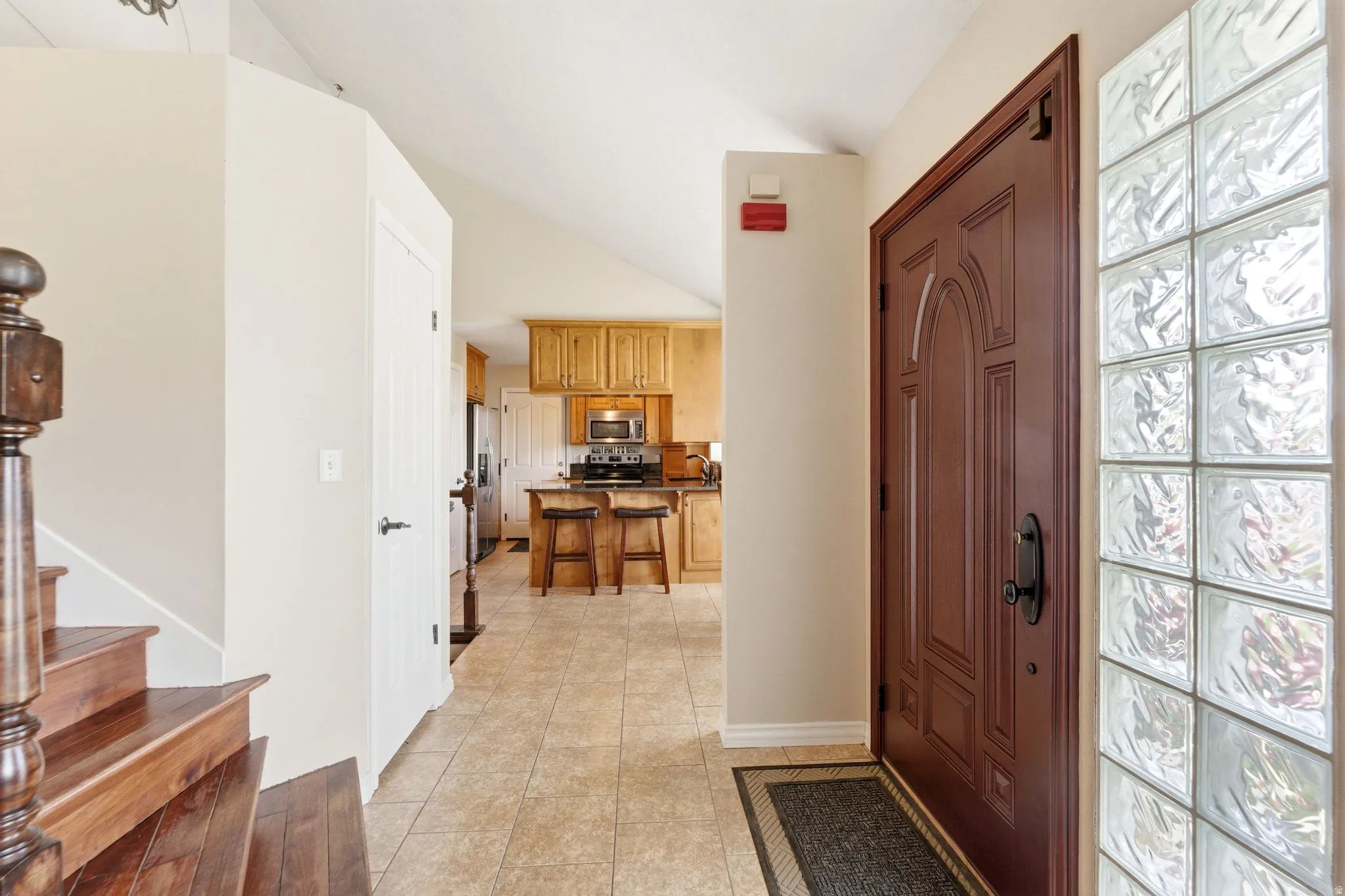 Entryway with light tile patterned floors and stairs