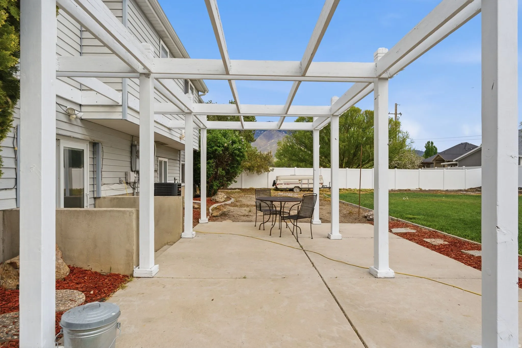 Fenced backyard with a pergola, a patio area, and outdoor dining area
