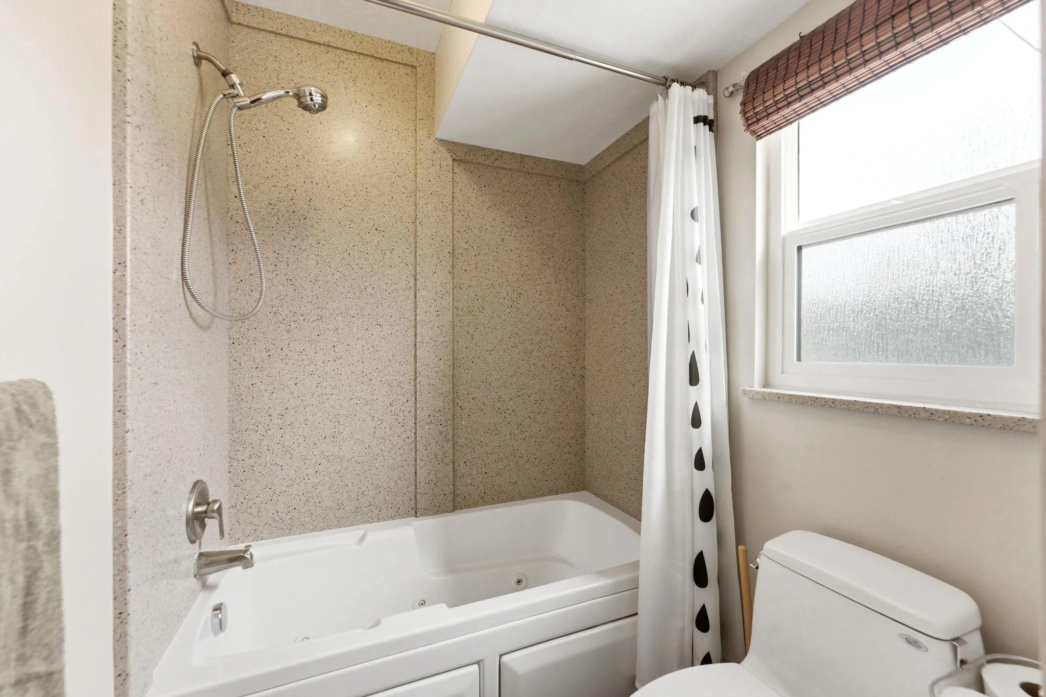 Full bathroom with a combined bath / shower with jetted tub and toilet