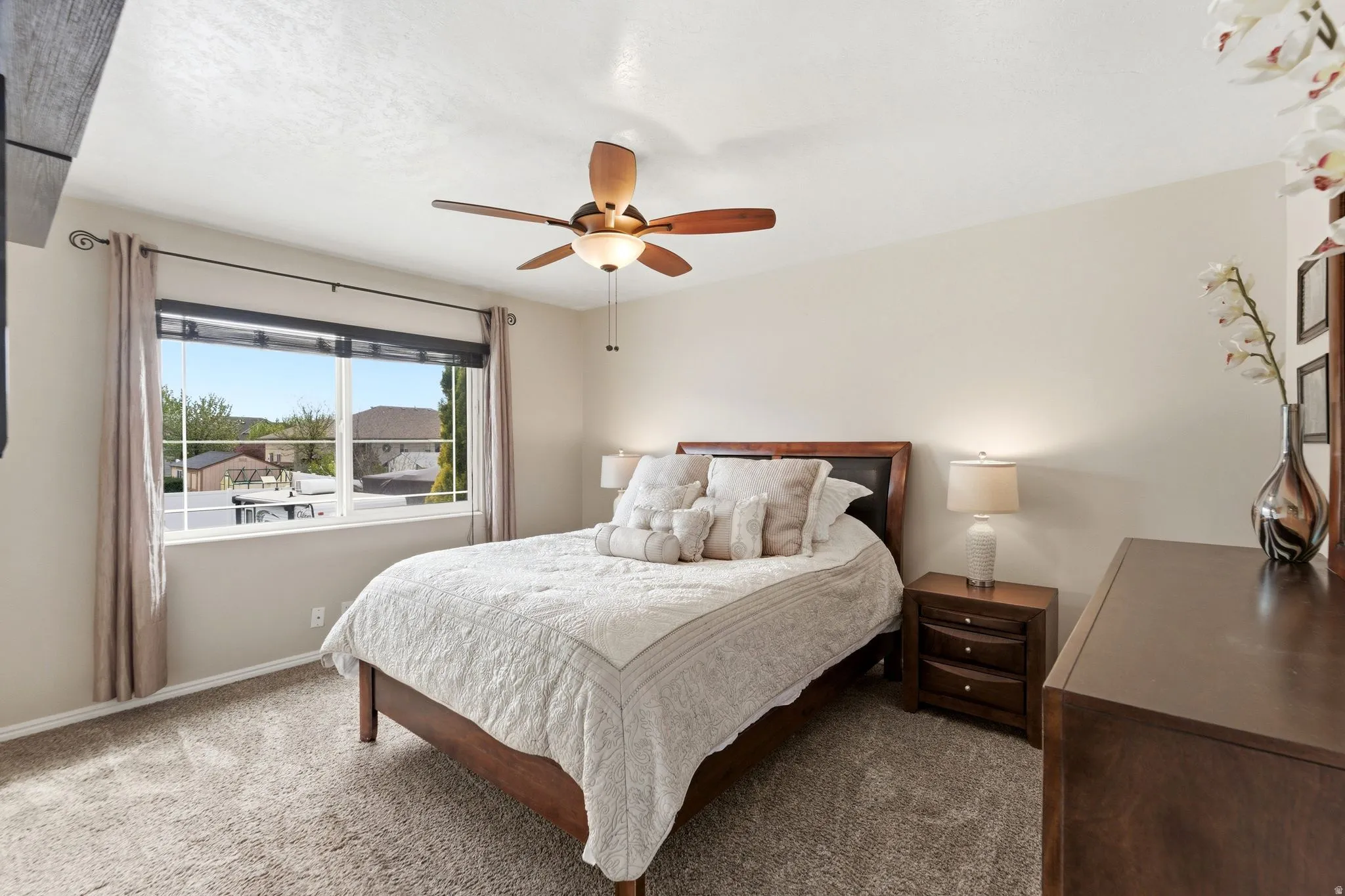 Carpeted bedroom featuring a ceiling fan and baseboards