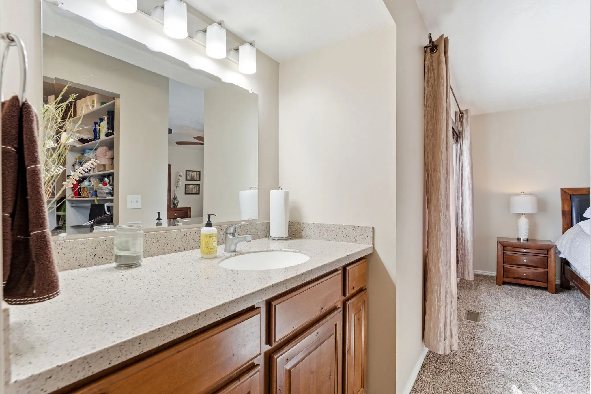 Ensuite bathroom featuring vanity, light colored carpet, and curtained shower