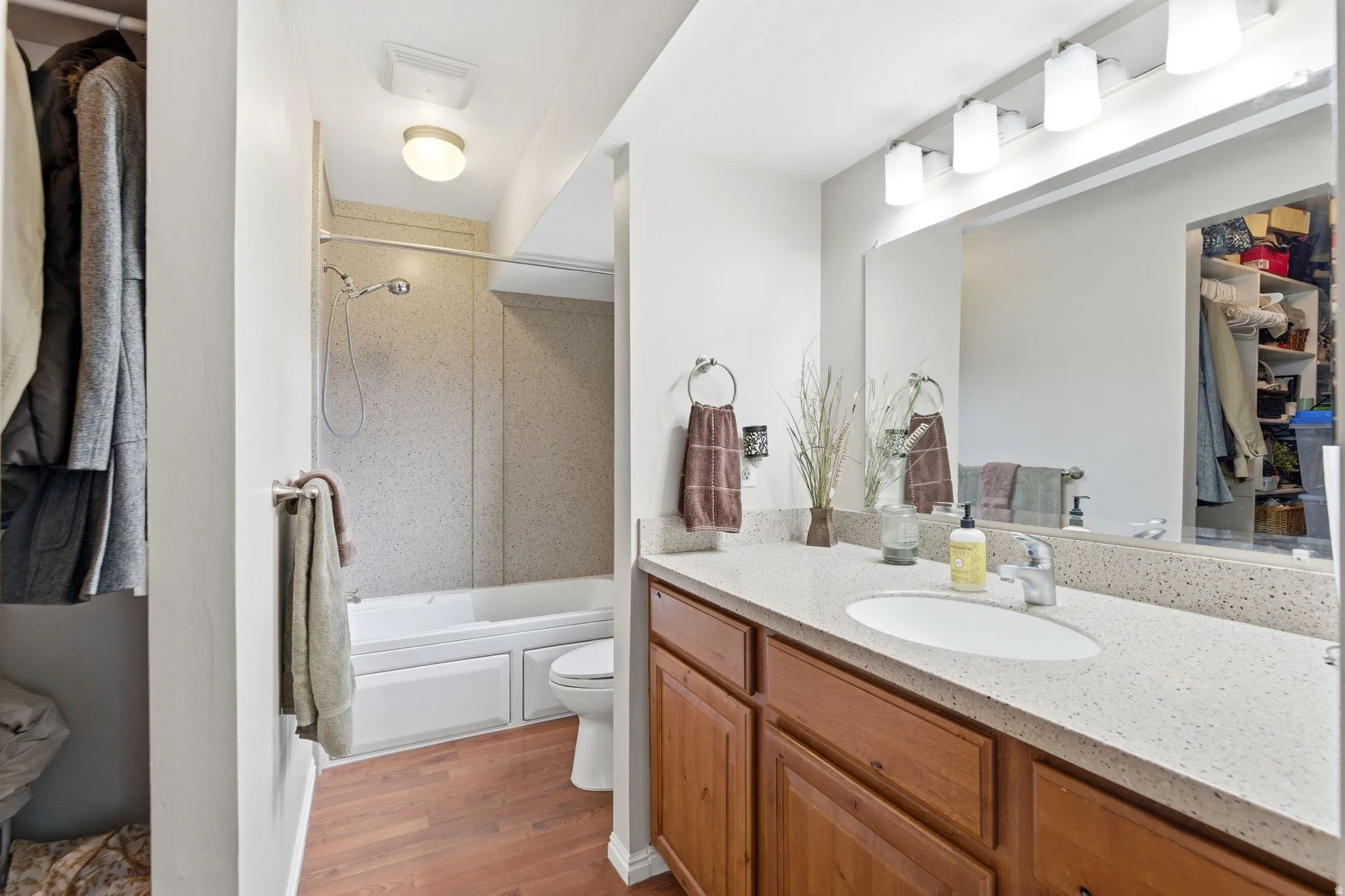 Bathroom featuring vanity, shower / washtub combination, and light wood-type flooring