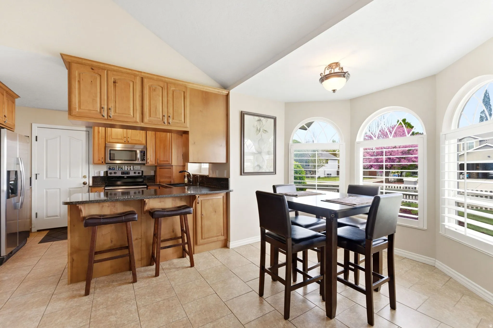 Dining room featuring vaulted ceiling and light tile patterned floors