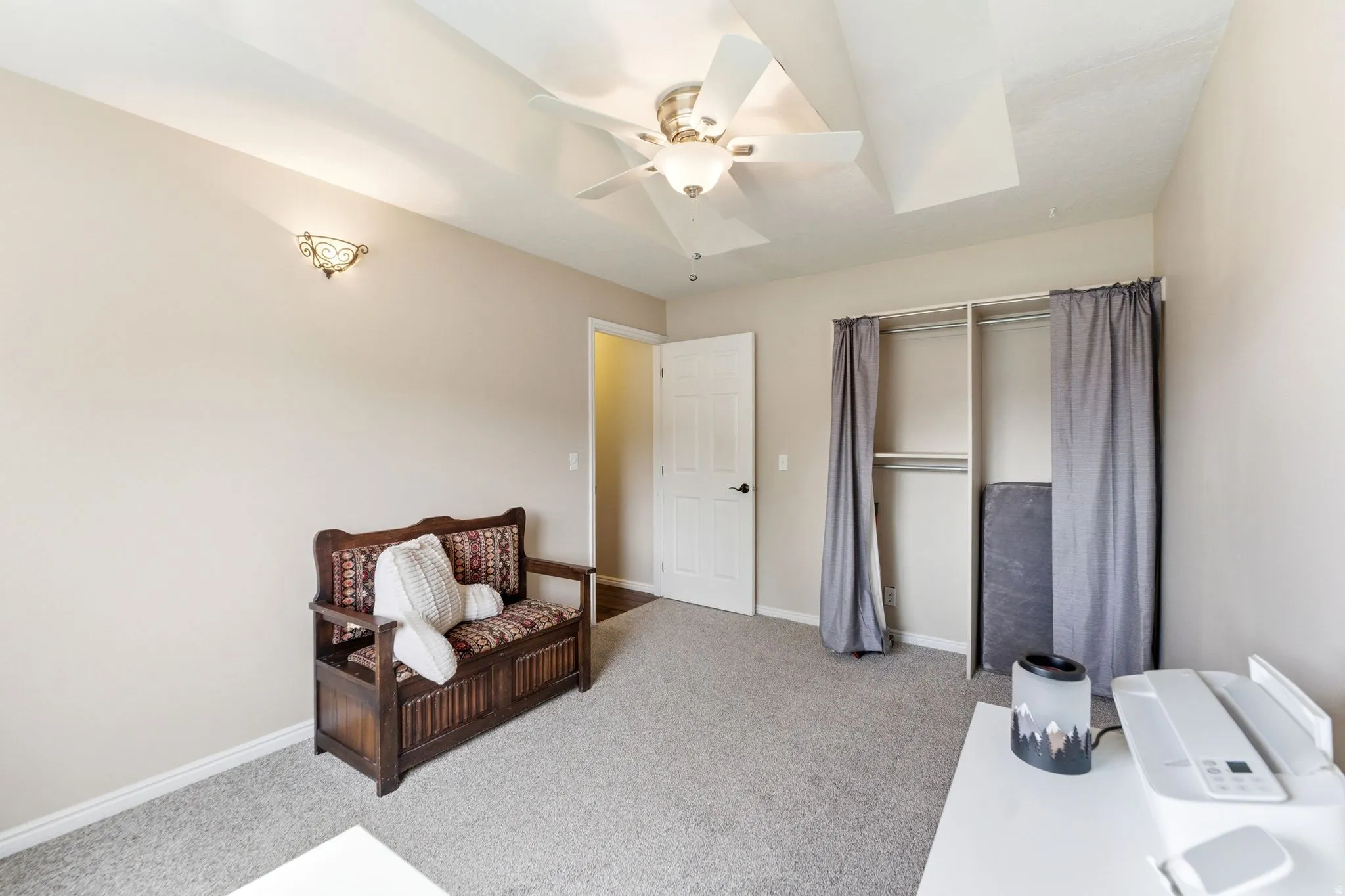 Living area featuring light colored carpet and ceiling fan