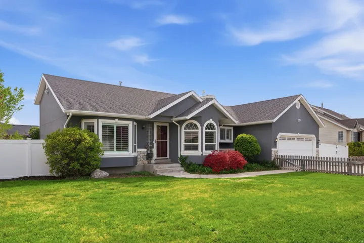 Ranch-style home with a garage, a shingled roof, and stucco siding