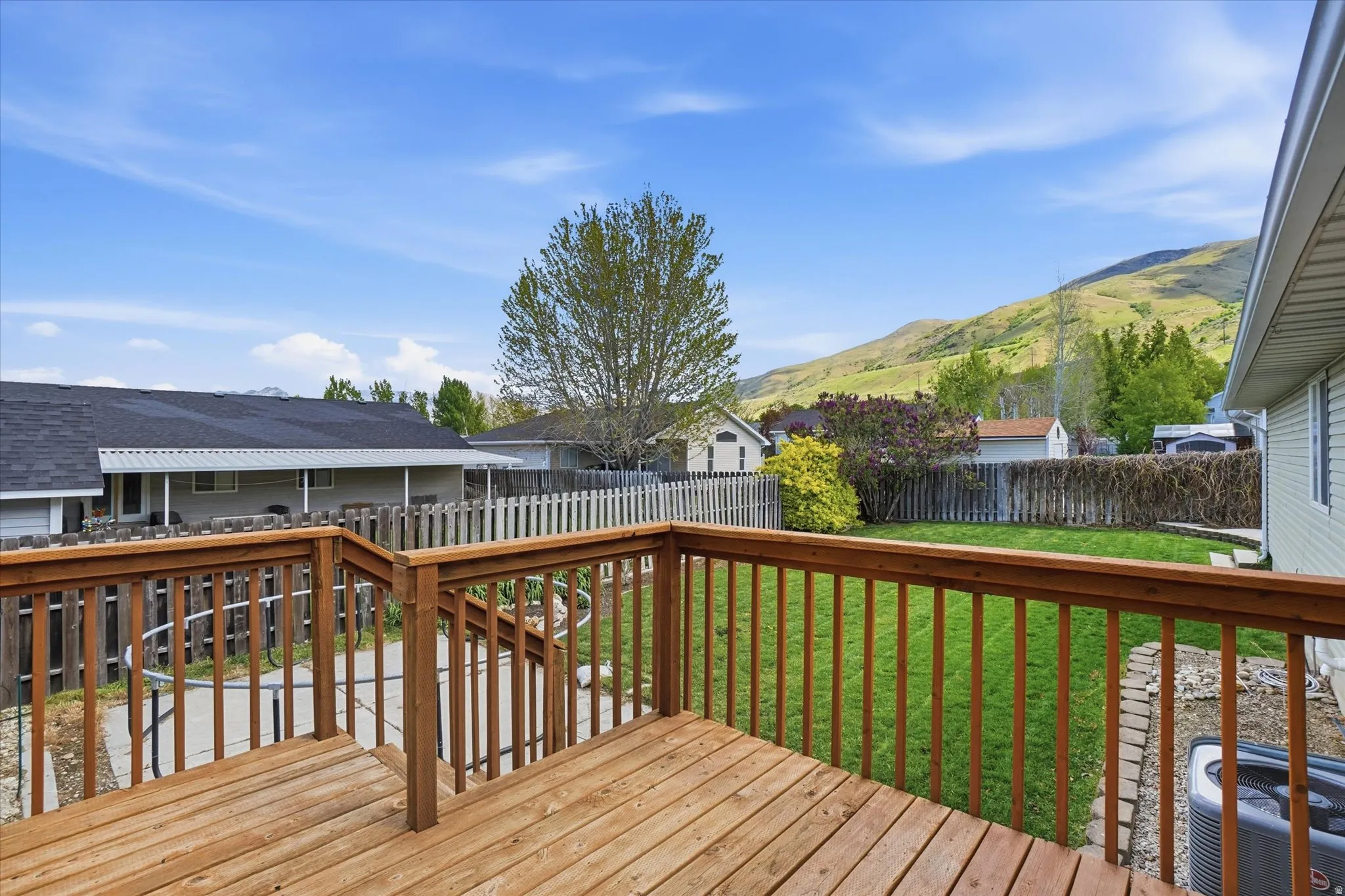 Wood deck in a fenced backyard with mountain view