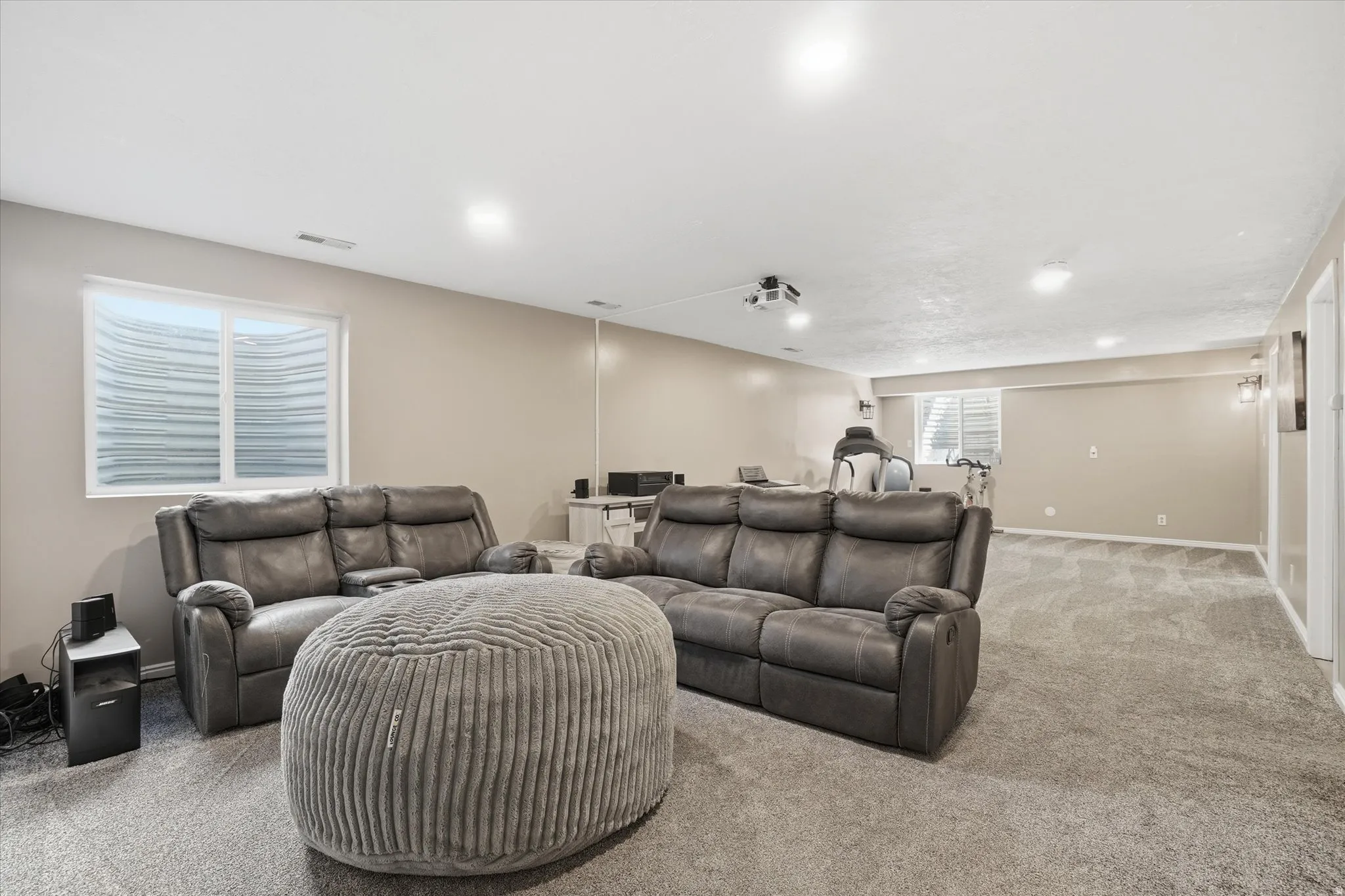 Carpeted home theater room with baseboards